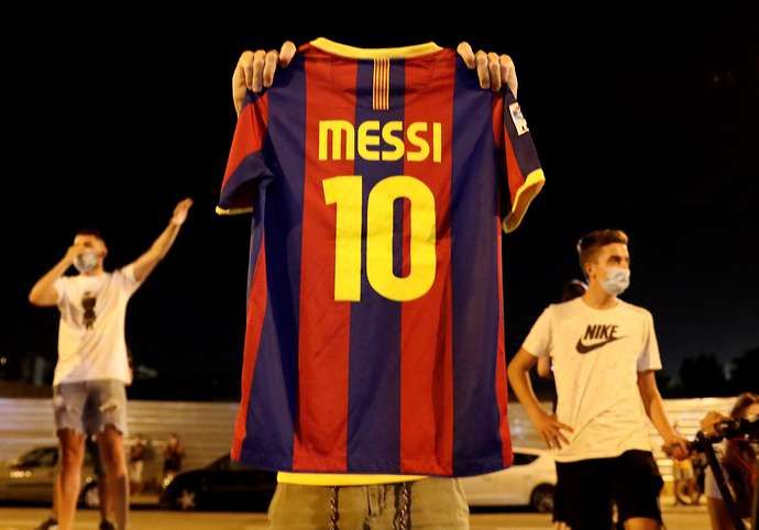 Barcelona fans hold up Messi shirts