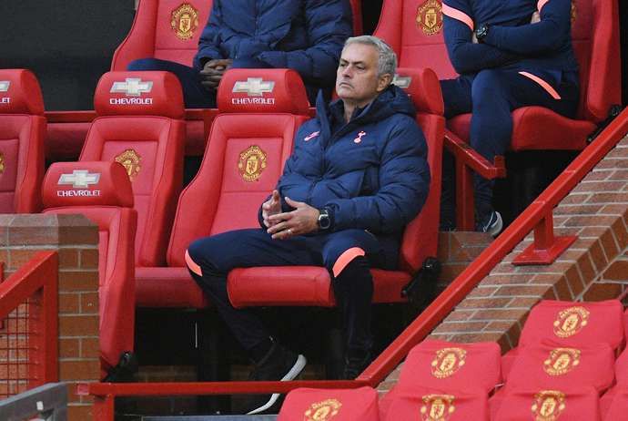 Jose Mourinho sits in the dugout at Old Trafford