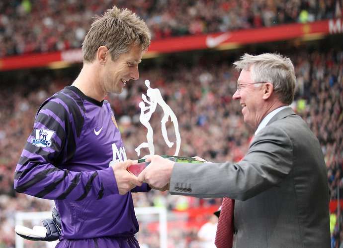 Sir Alex Ferguson hands an award to Edwin van der Sar