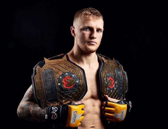 UFC fighter Mason Jones displays his Cage Warriors belts.