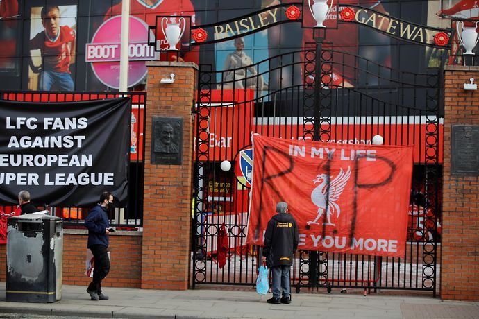 People stand in front of anti Super League banners outside Anfield