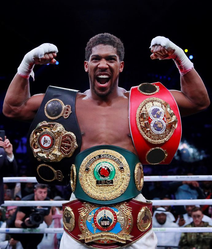 Anthony Joshua poses with four heavyweight belts