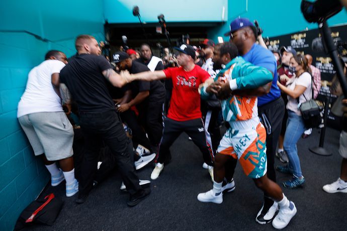 Floyd Mayweather is held back by security after Jake Paul steals his hat.