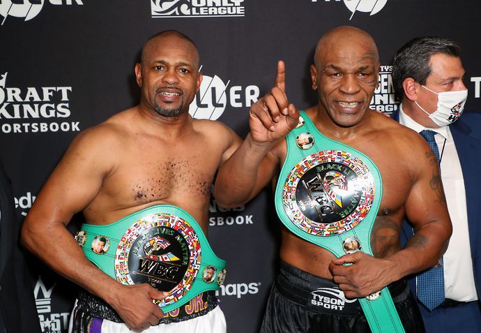 Roy Jones Jr celebrates with Mike Tyson after their exhibition fight