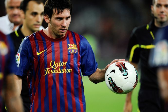 Lionel Messi of FC Barcelona leaves the pitch with the match ball after scoring a hat-trick at the end of the La Liga soccer match between FC Barcelona and CA Osasuna