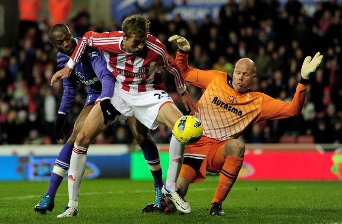 Brad Friedel tussles with Peter Crouch