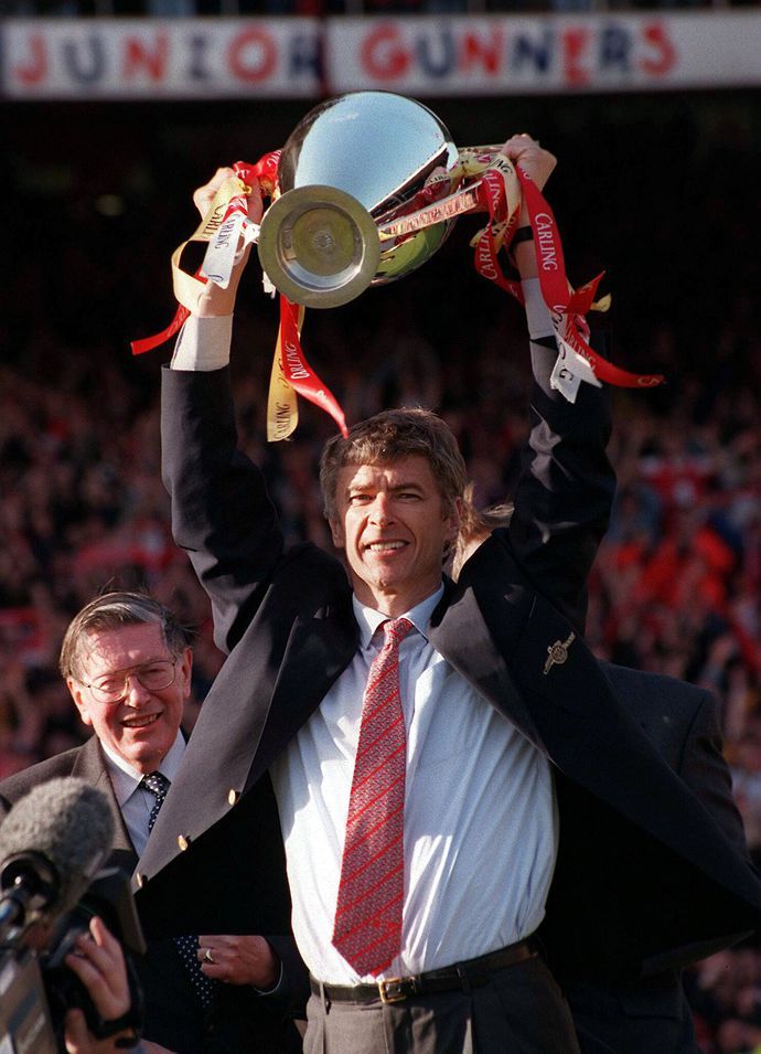 Arsene Wenger holding aloft the Premier League trophy