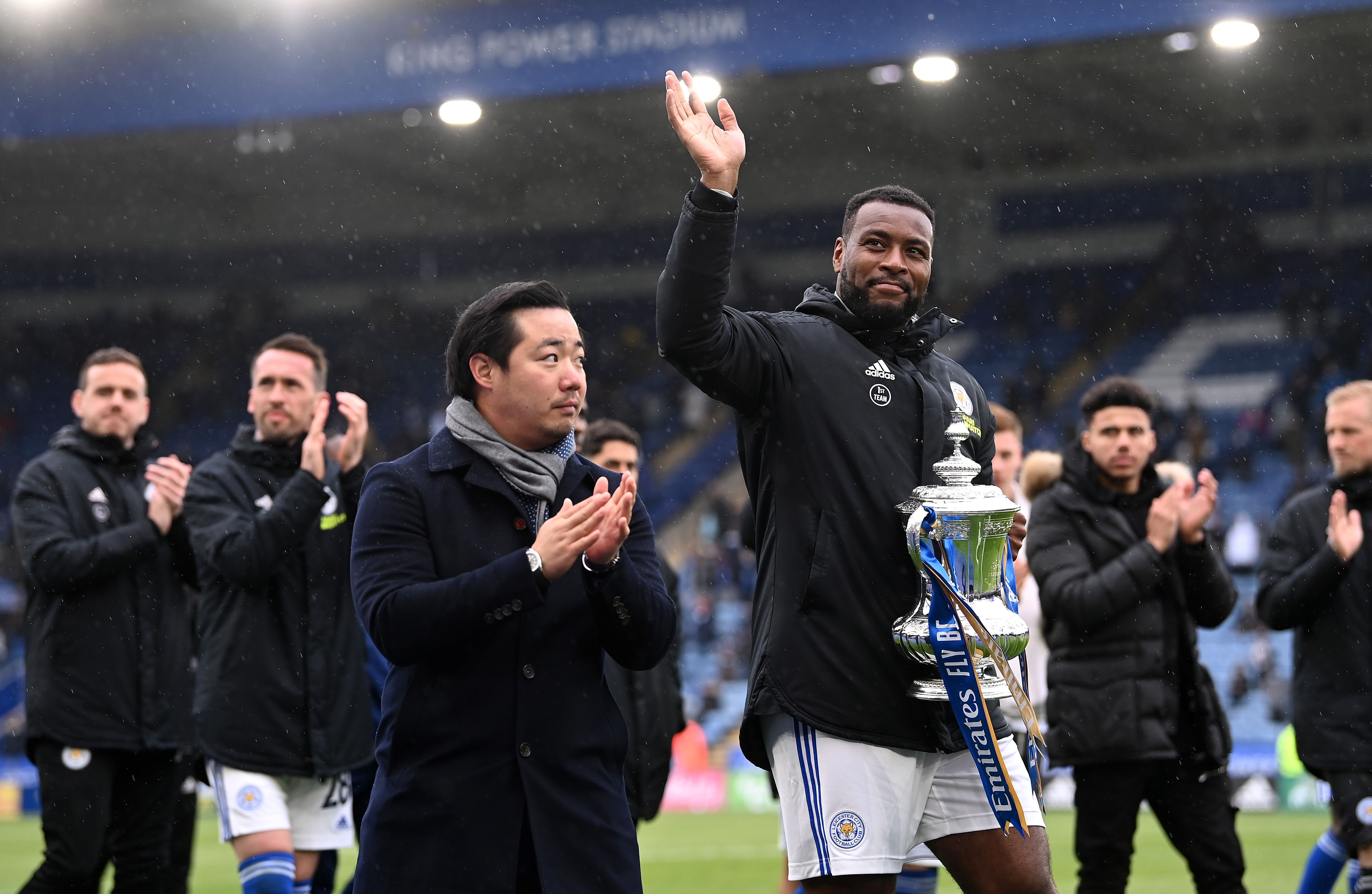 Leicester City and Wes Morgan of Leicester City carry the FA Cup Trophy to show their fans