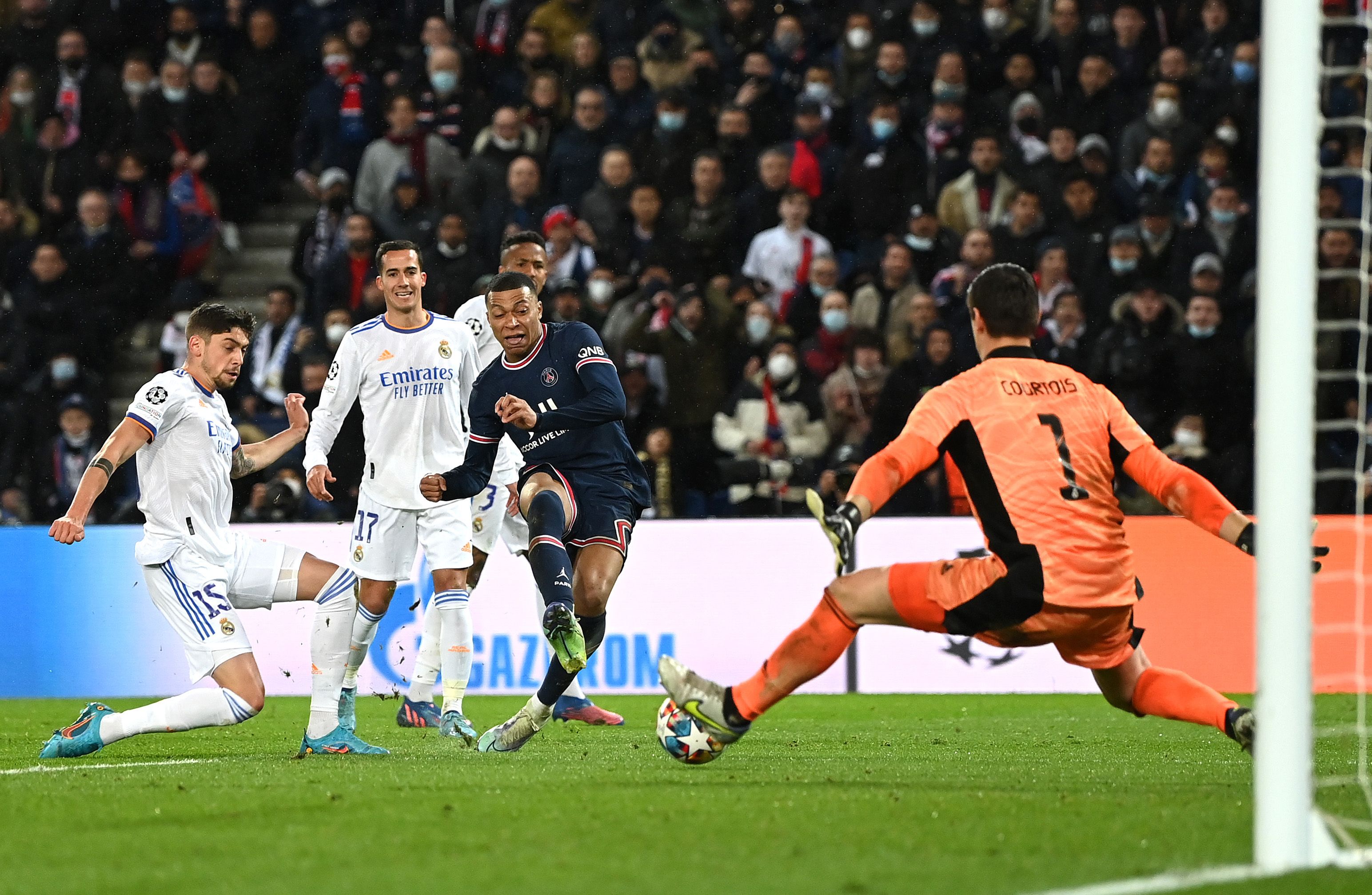 Kylian Mbappe of Paris Saint-Germain shoots to score past Thibaut Courtois of Real Madrid during the UEFA Champions League Round Of Sixteen First Leg match between Paris Saint-Germain and Real Madrid at Parc des Princes on February 15, 2022 in Paris, France.