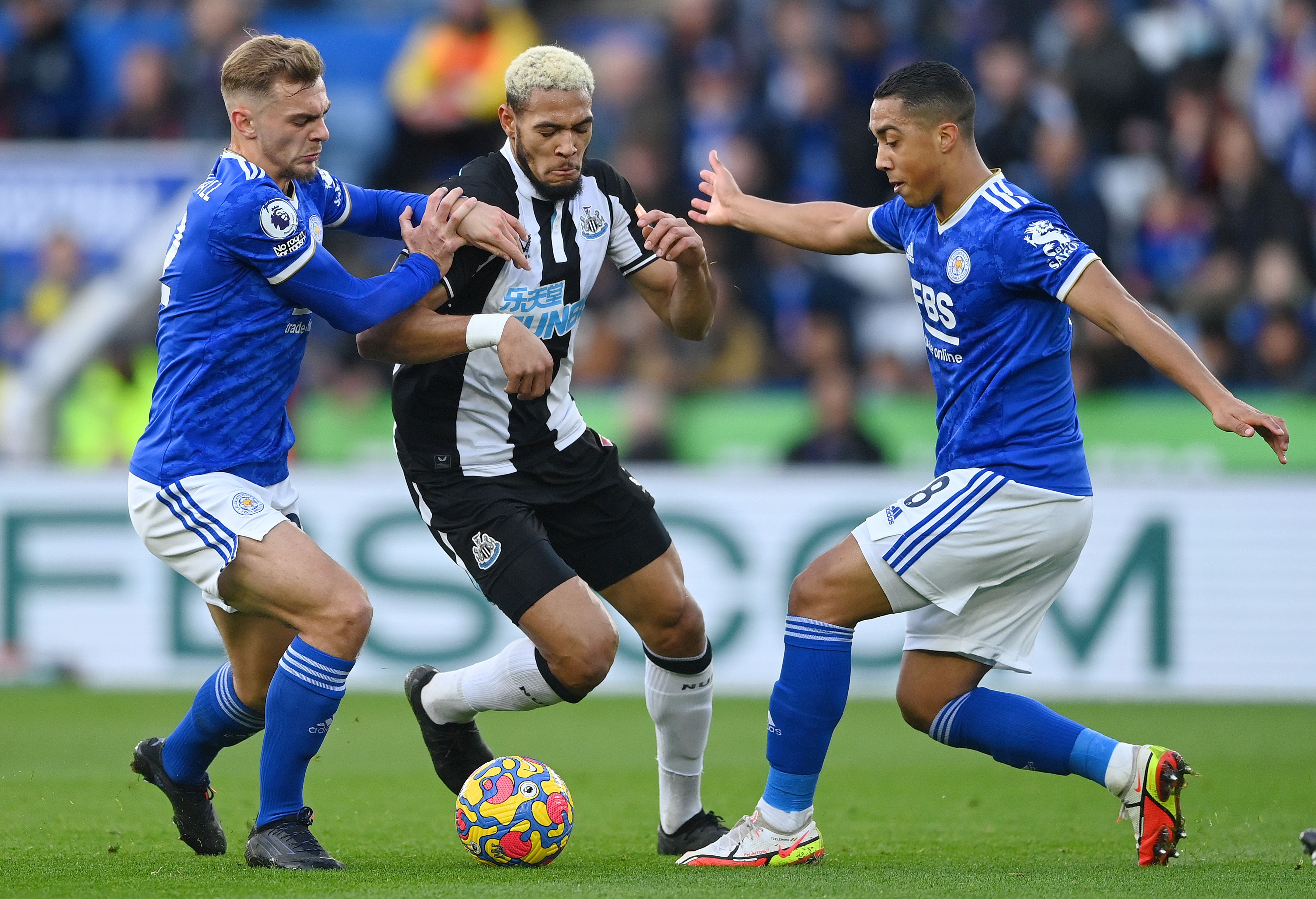 Joelinton of Newcastle United battles for possession with Dewsbury-Hall and Youri Tielemans of Leicester 
