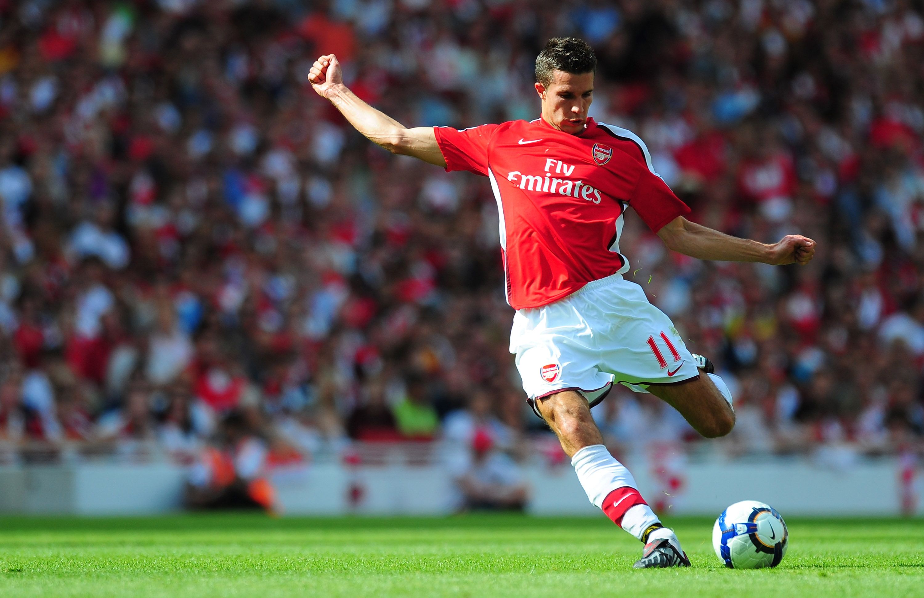 Robin van Persie of Arsenal crosses the ball during a match