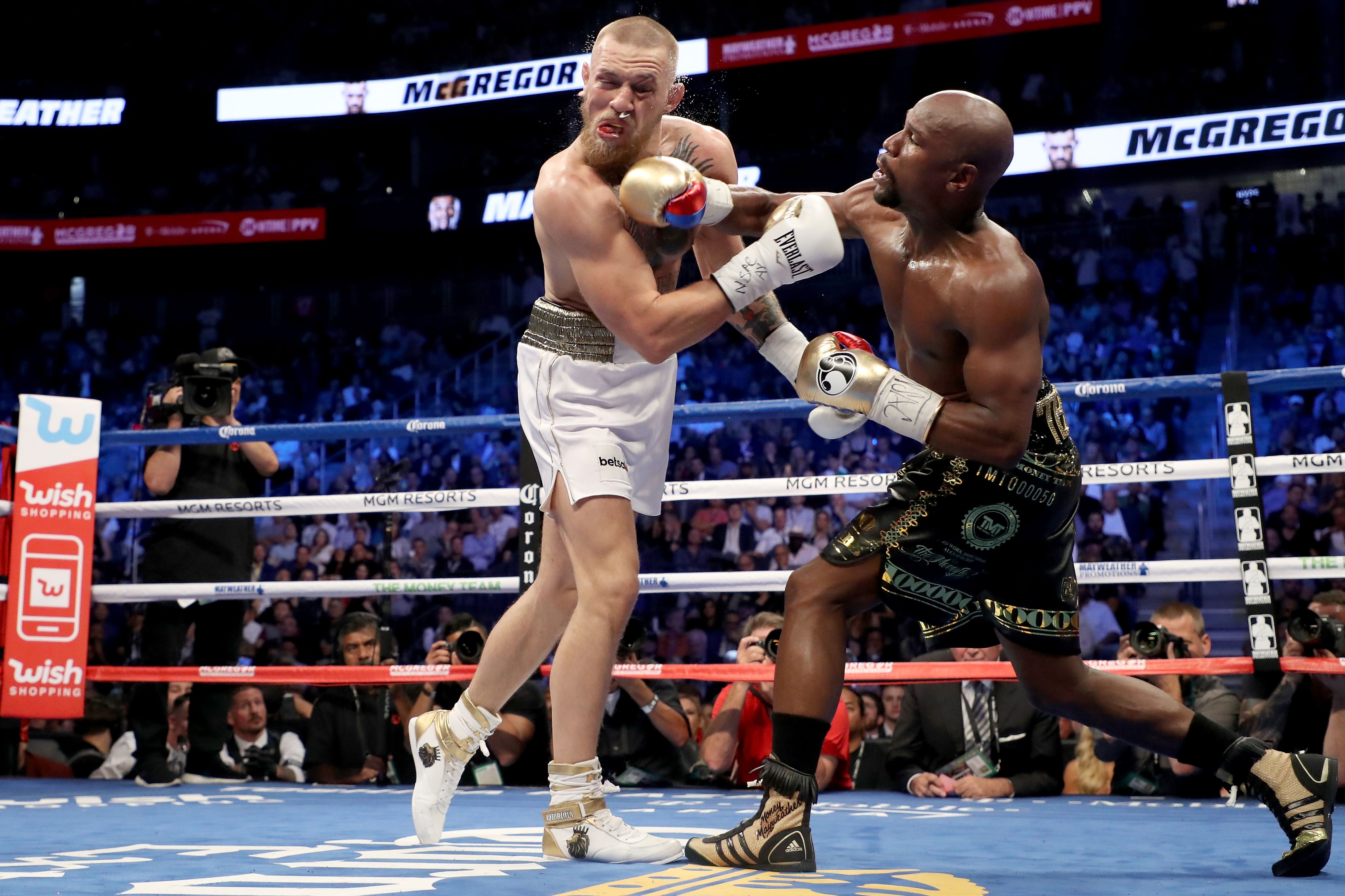 Floyd Mayweather lands a punch on Conor McGregor