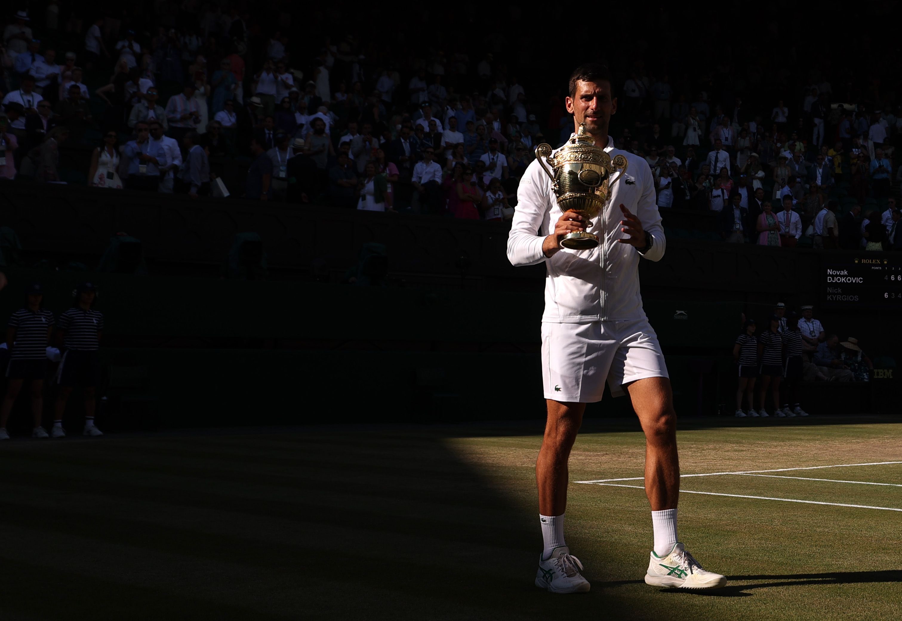 Novak Djokovic of Serbia celebrates with the trophy following his victory against Nick Kyrgios of Australia during their Men's Singles Final match on day fourteen of The Championships Wimbledon 2022 at All England Lawn Tennis and Croquet Club on July 10, 2022 in London, England.