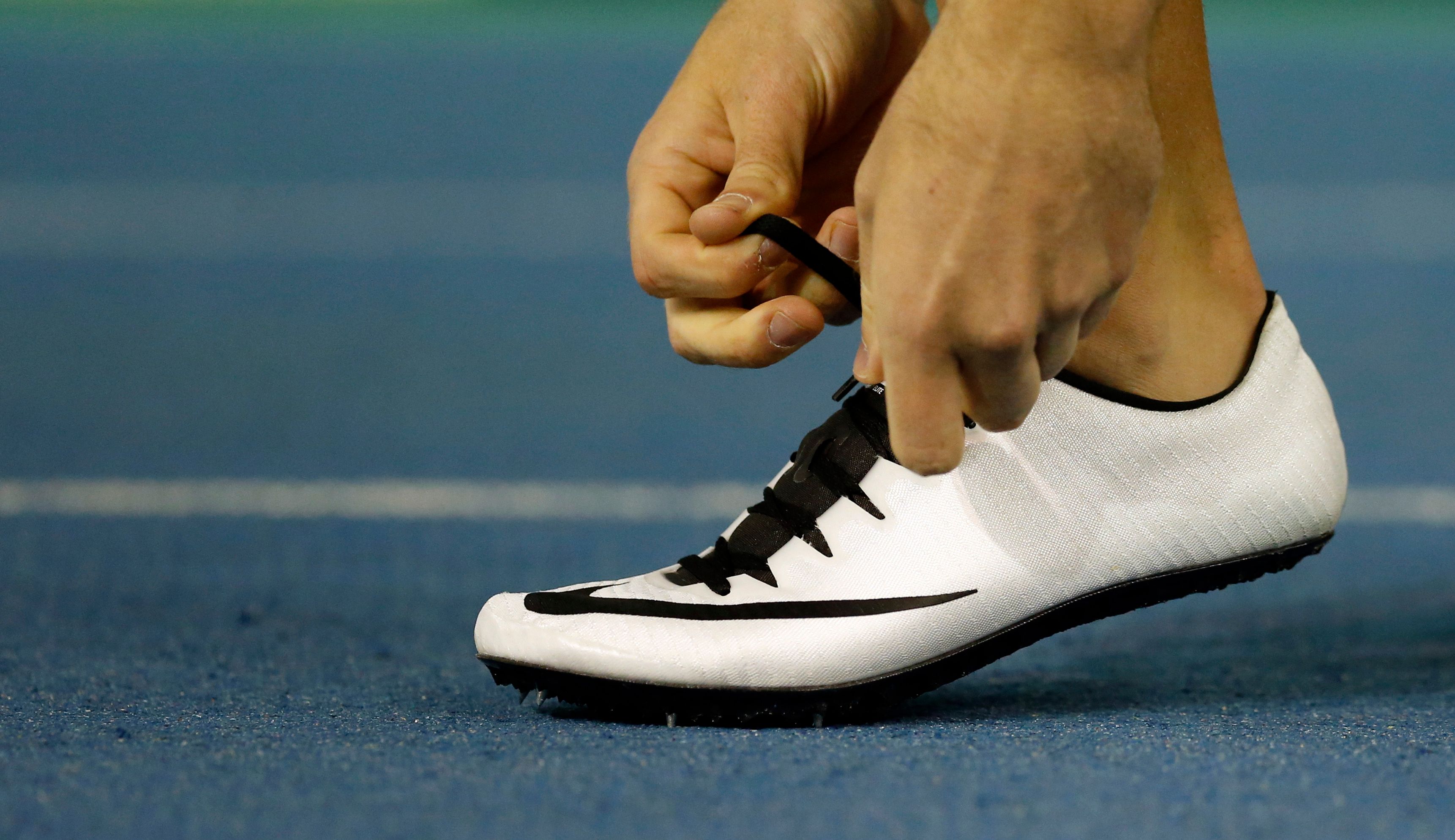 Athlete tying up their spikes.