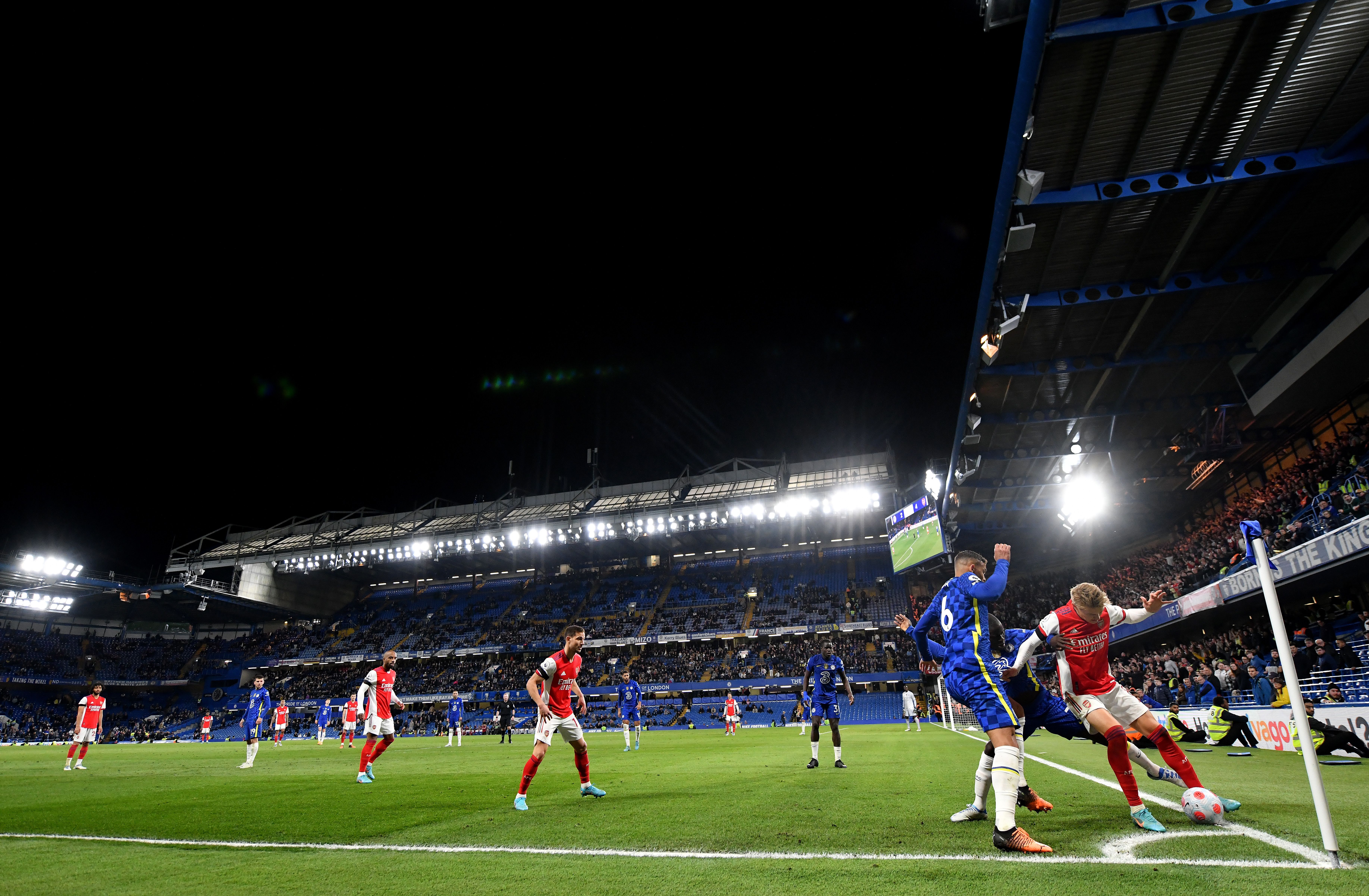 Martin Odegaard of Arsenal holds the ball in the corner under pressure from Thiago Silva of Chelsea 