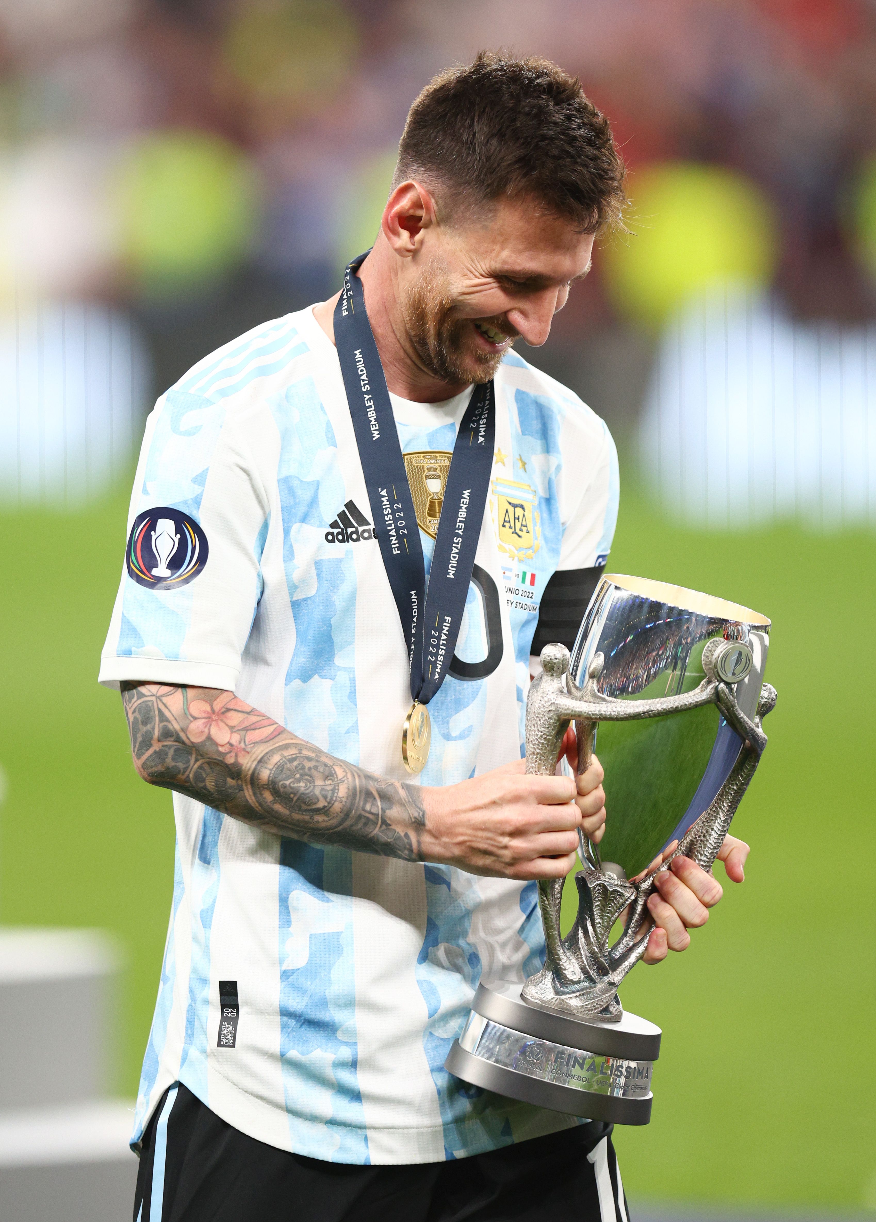 Lionel Messi celebrates with a trophy