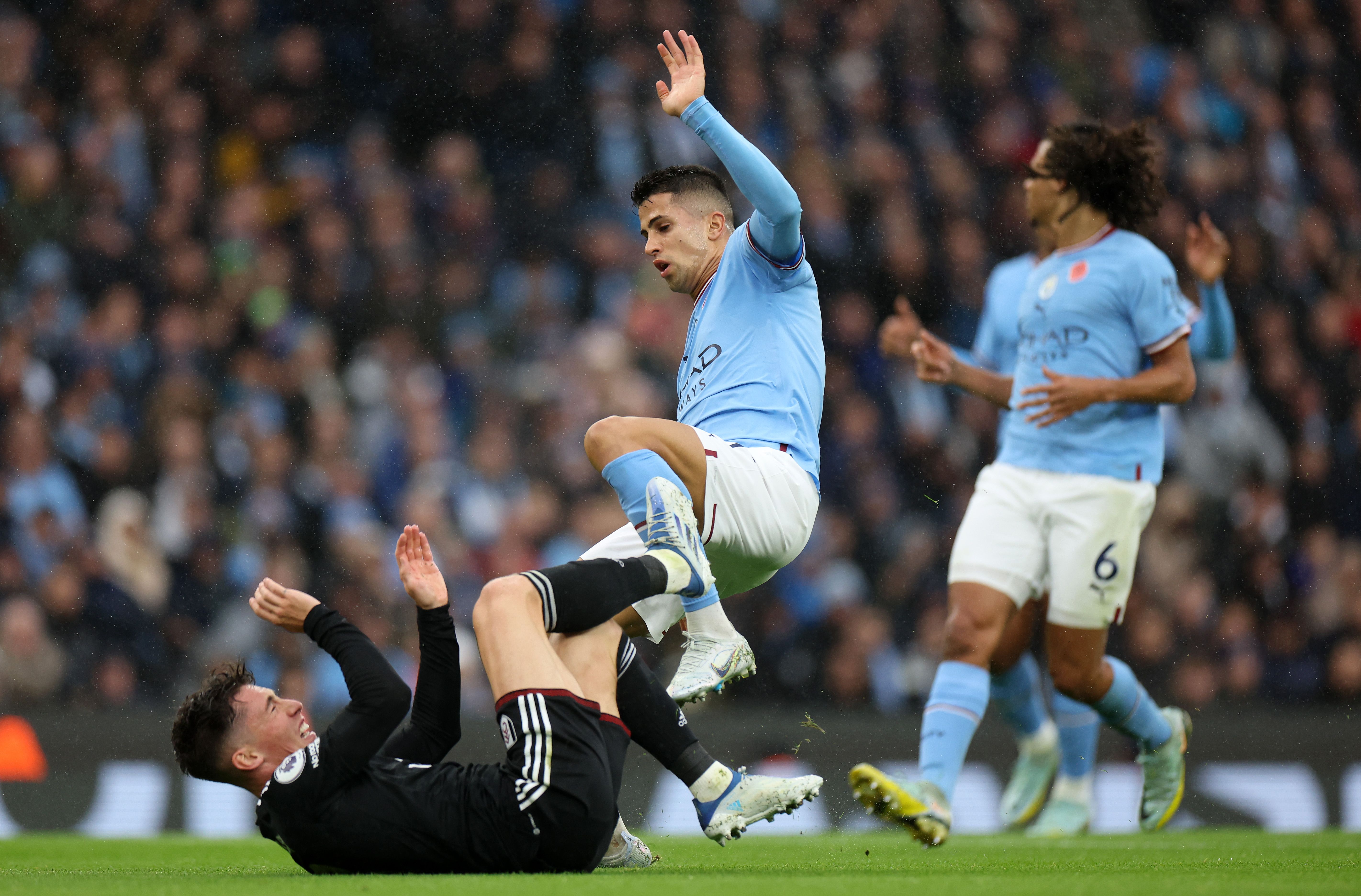 Joao Cancelo of Manchester City getting tackled