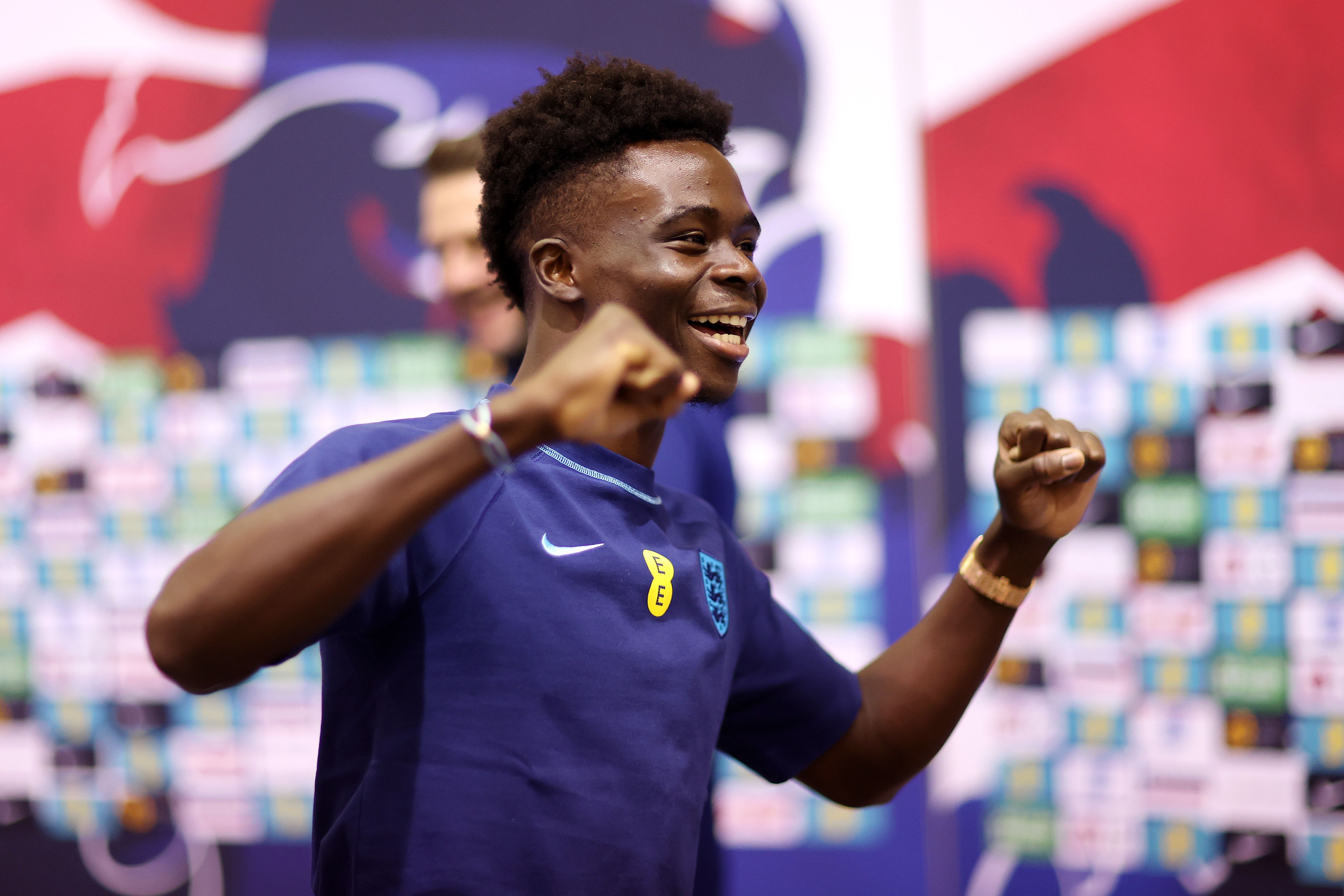 Bukayo Saka of England reacts after playing dartsduring the England Press Conference on the day after the Round of 16 match against Senegal at Al Wakrah Stadium on December 05, 2022 in Doha, Qatar