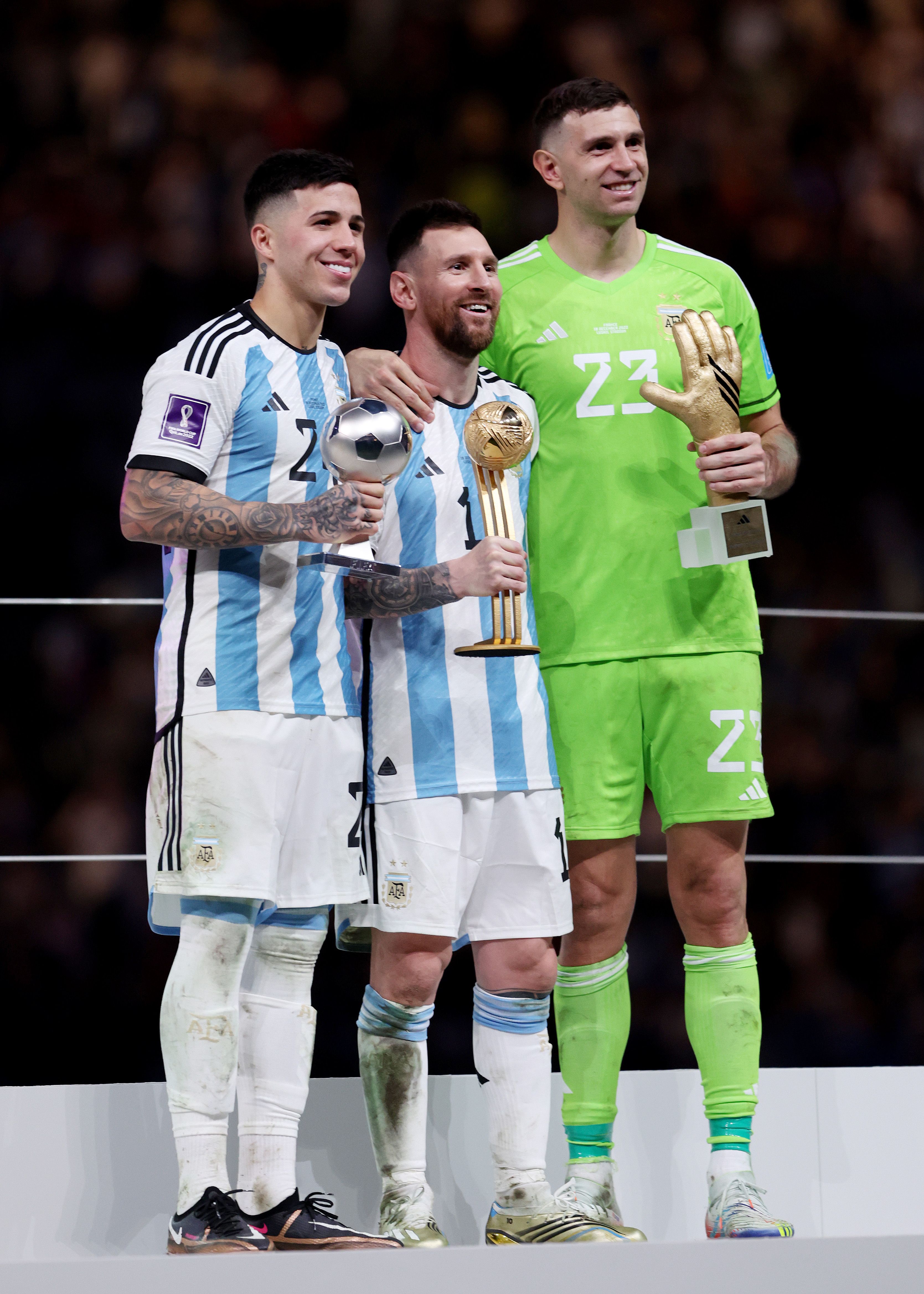 Fernández y Messi sostienen sus premios del Mundial.