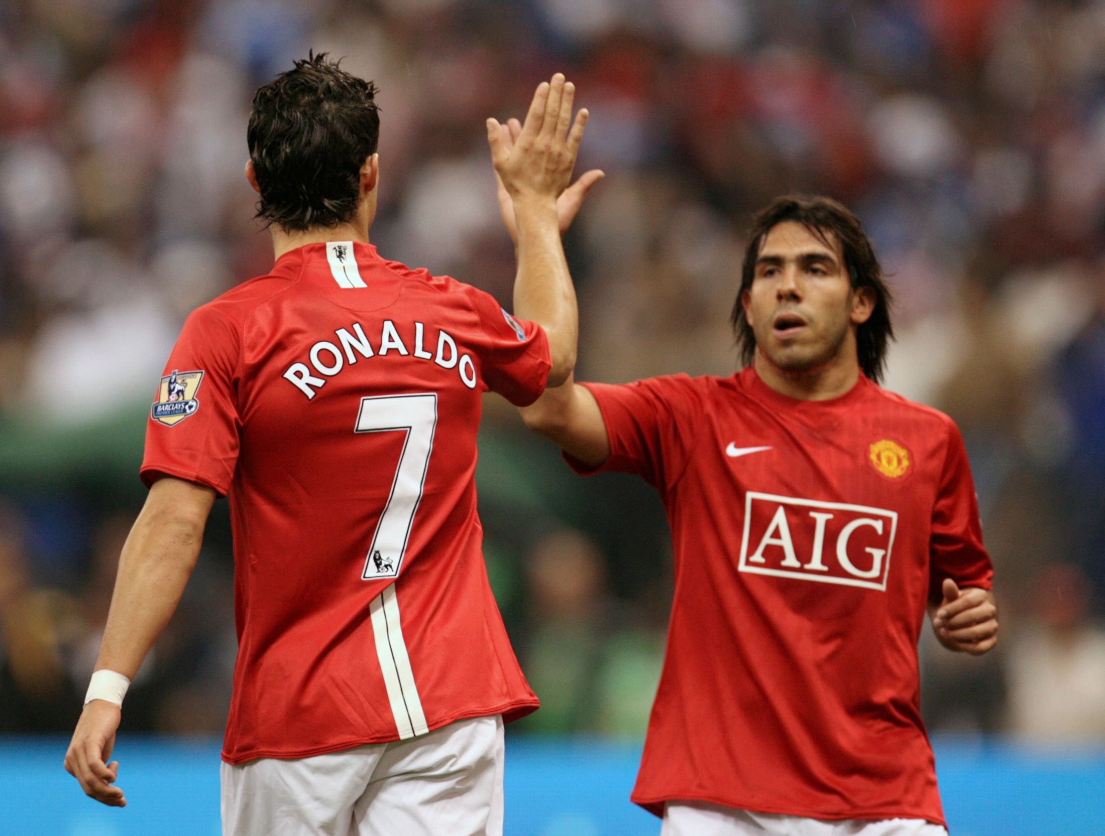 Manchester United's Cristiano Ronaldo (L) high-fives his team mate Carlos Tevez.