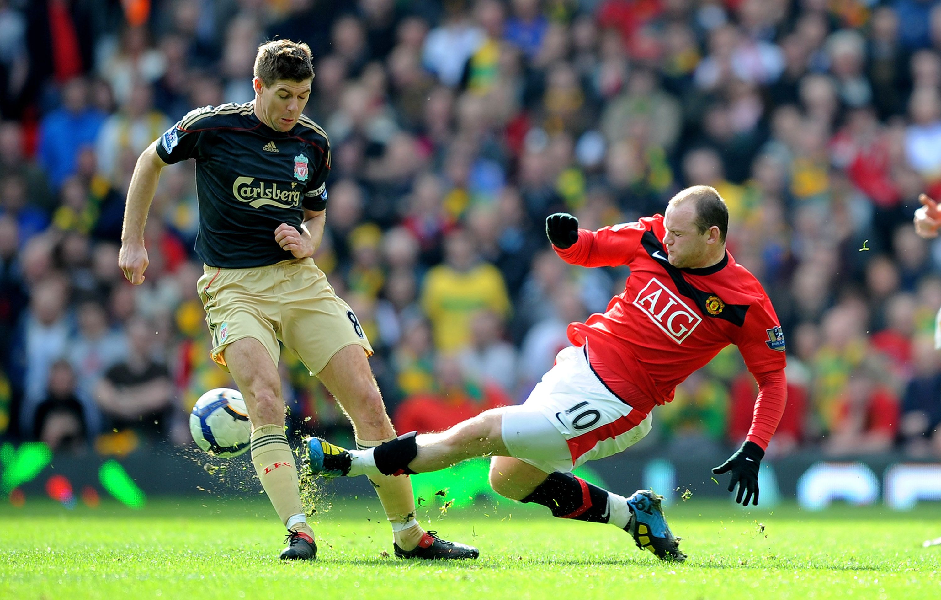 MANCHESTER, ENGLAND - MARCH 21: Steven Gerrard of Liverpool is tackled by Wayne Rooney of Manchester United during the Barclays Premier League match between Manchester United and Liverpool at Old Trafford on March 21, 2010 in Manchester, England. (Photo by Michael Regan/Getty Images)