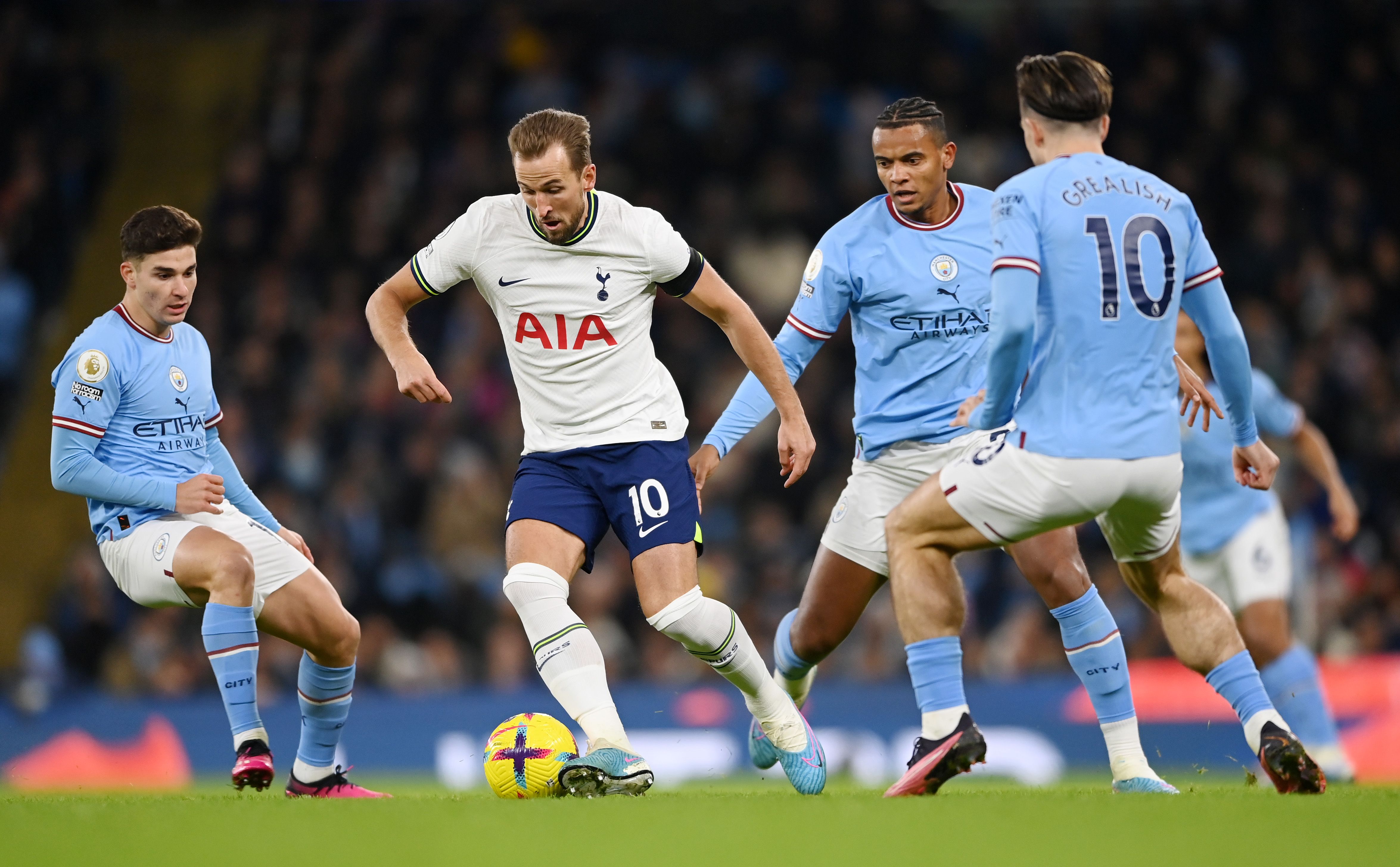  Harry Kane of Tottenham Hotspur is challenged by Julian Alvarez and Manuel Akanji of Manchester City during the Premier League match between Manchester City and Tottenham Hotspur at Etihad Stadium on January 19, 2023 in Manchester, England. 