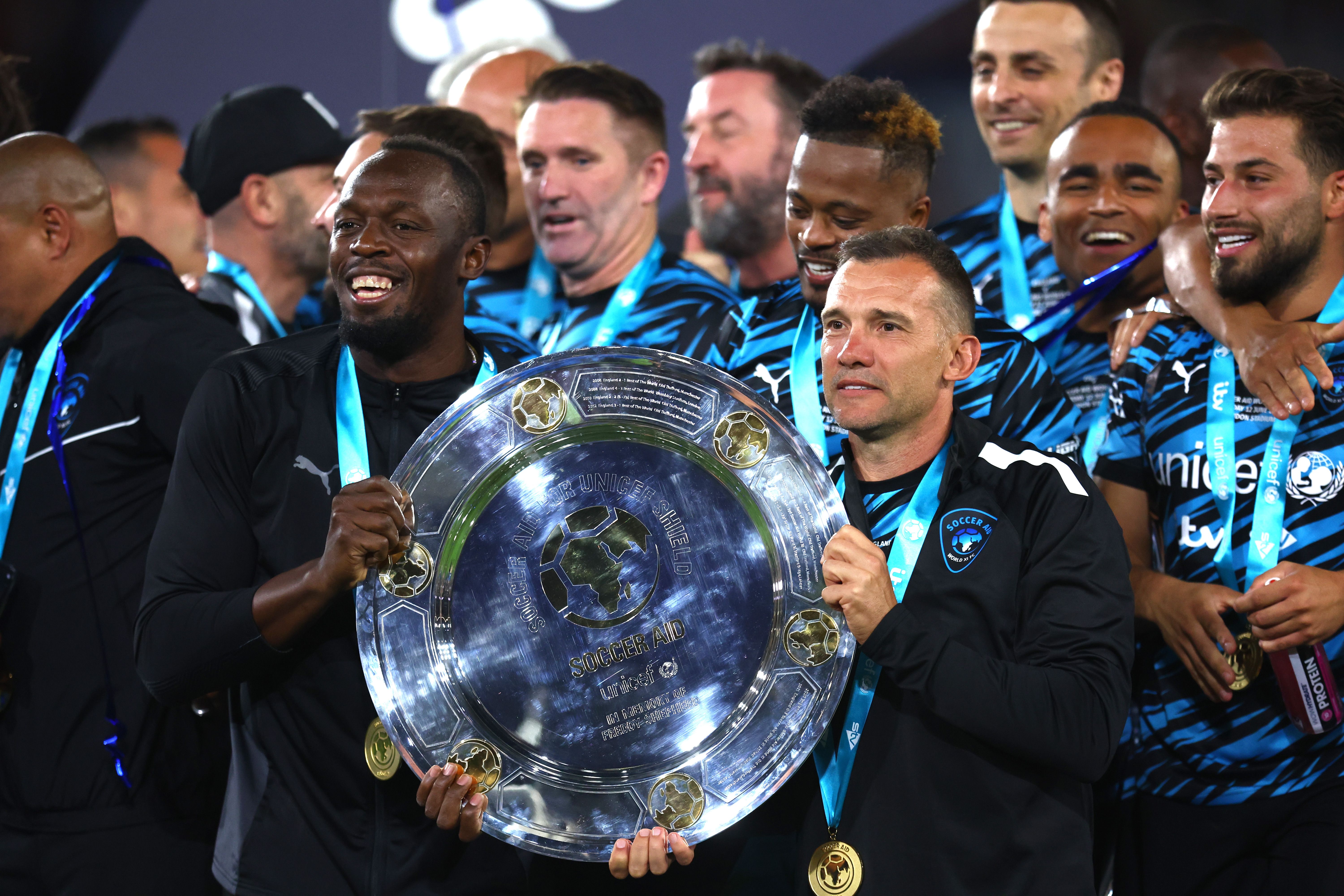Usain Bolt and Andriy Shevchenko of Team World XI lift the trophy as they celebrate victory after the Soccer Aid for Unicef 2022 at London Stadium on June 12, 2022 in London, England