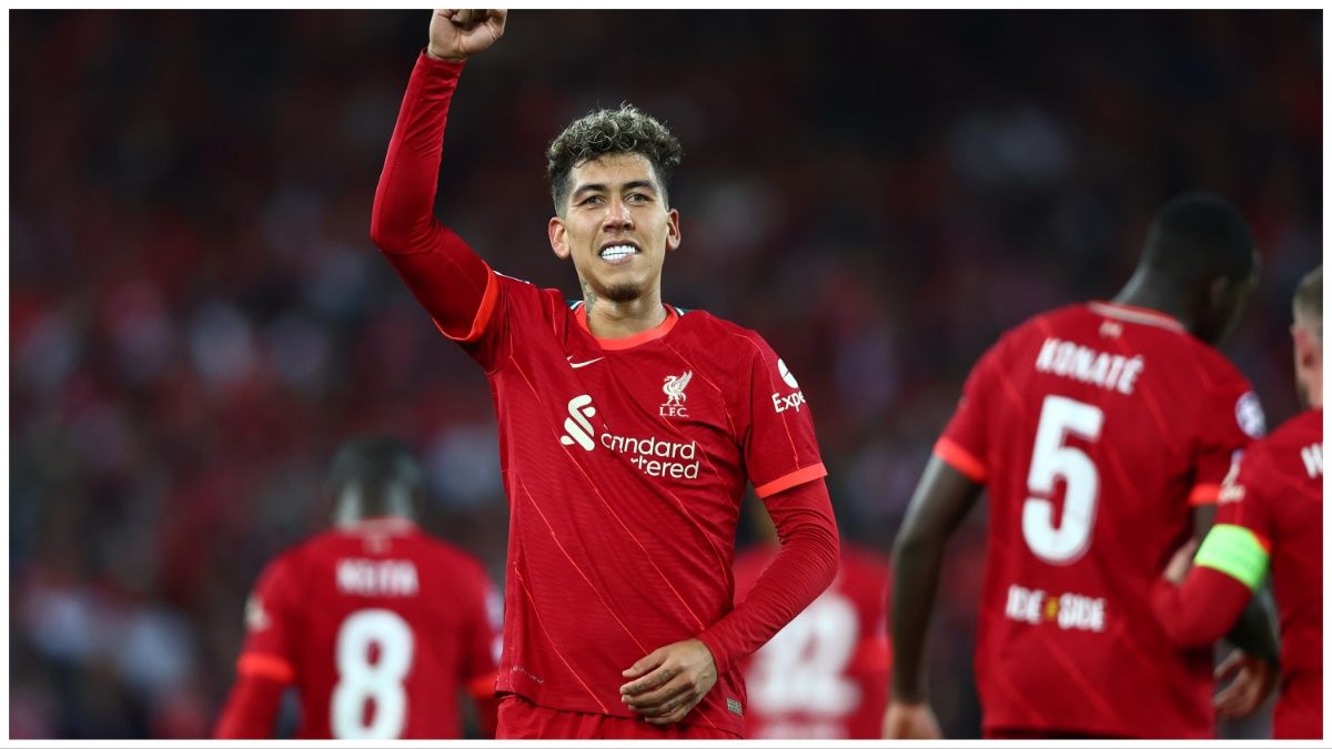 Liverpool forward Roberto Firmino smiles and celebrates with his arm raised to fans