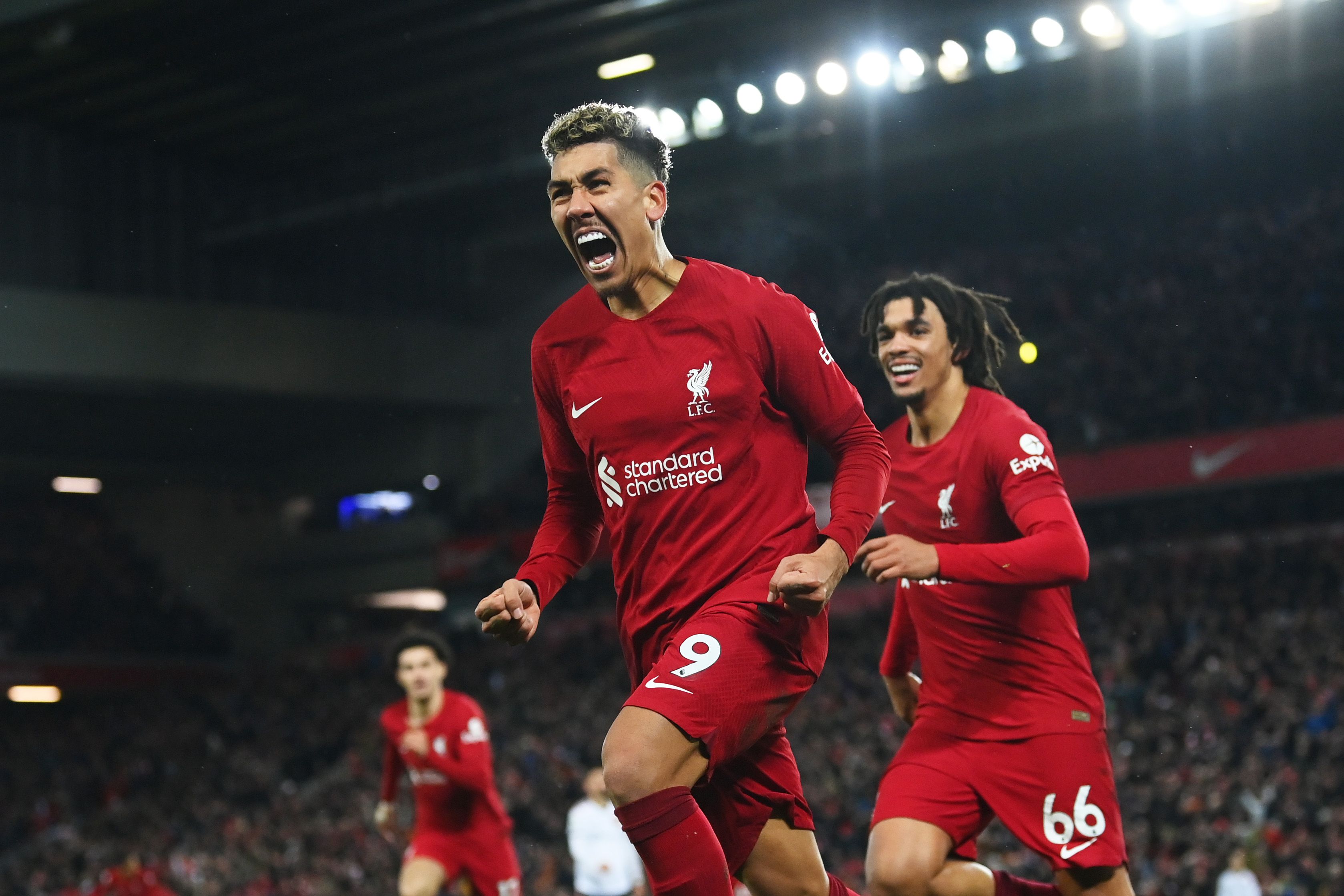 Liverpool's Roberto Firmino celebrates a goal by running towards the Kop closely followed by Trent Alexander-Arnold