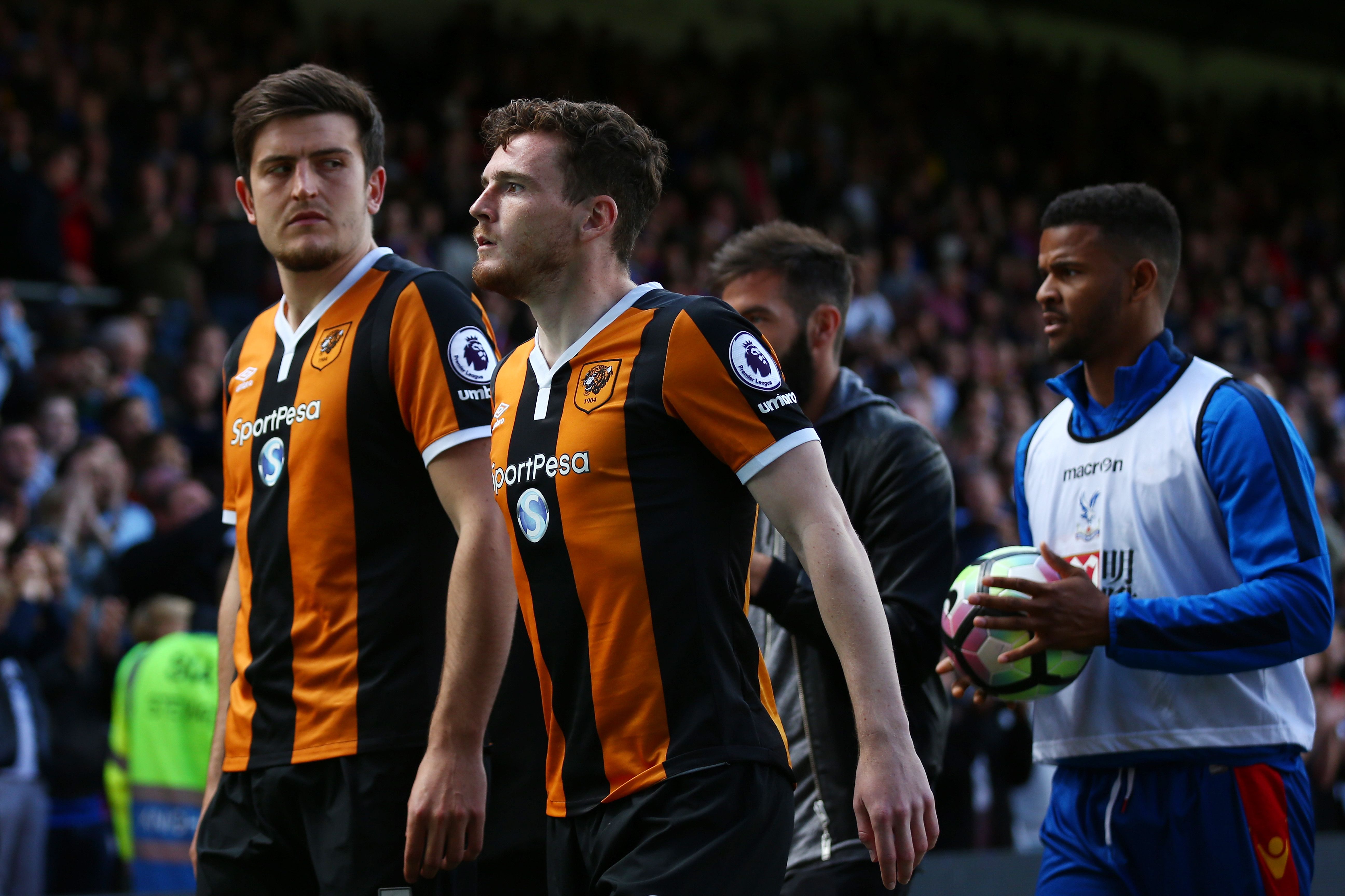 Harry Maguire of Hull City and Andrew Robertson of Hull City leave the pitch looking dejected after being relegated.
