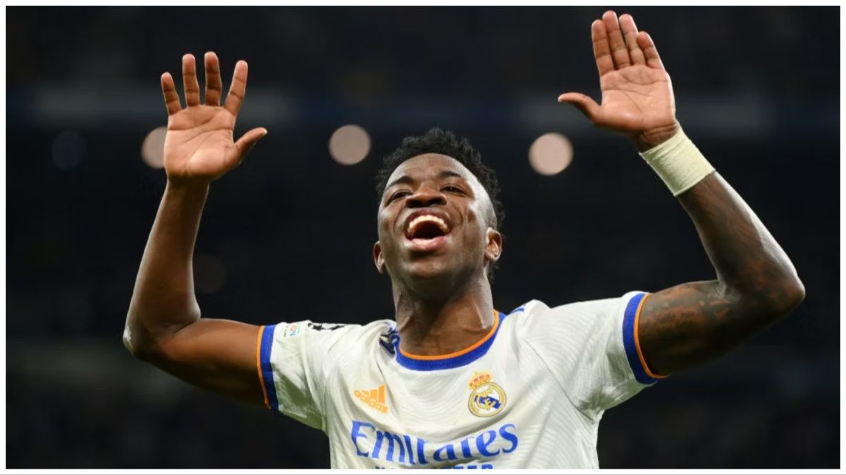 Vinicius Junior celebrates for Real Madrid in the UEFA Champions League Round of 16 tie at home to Paris Saint-Germain with his arms raised in the air.