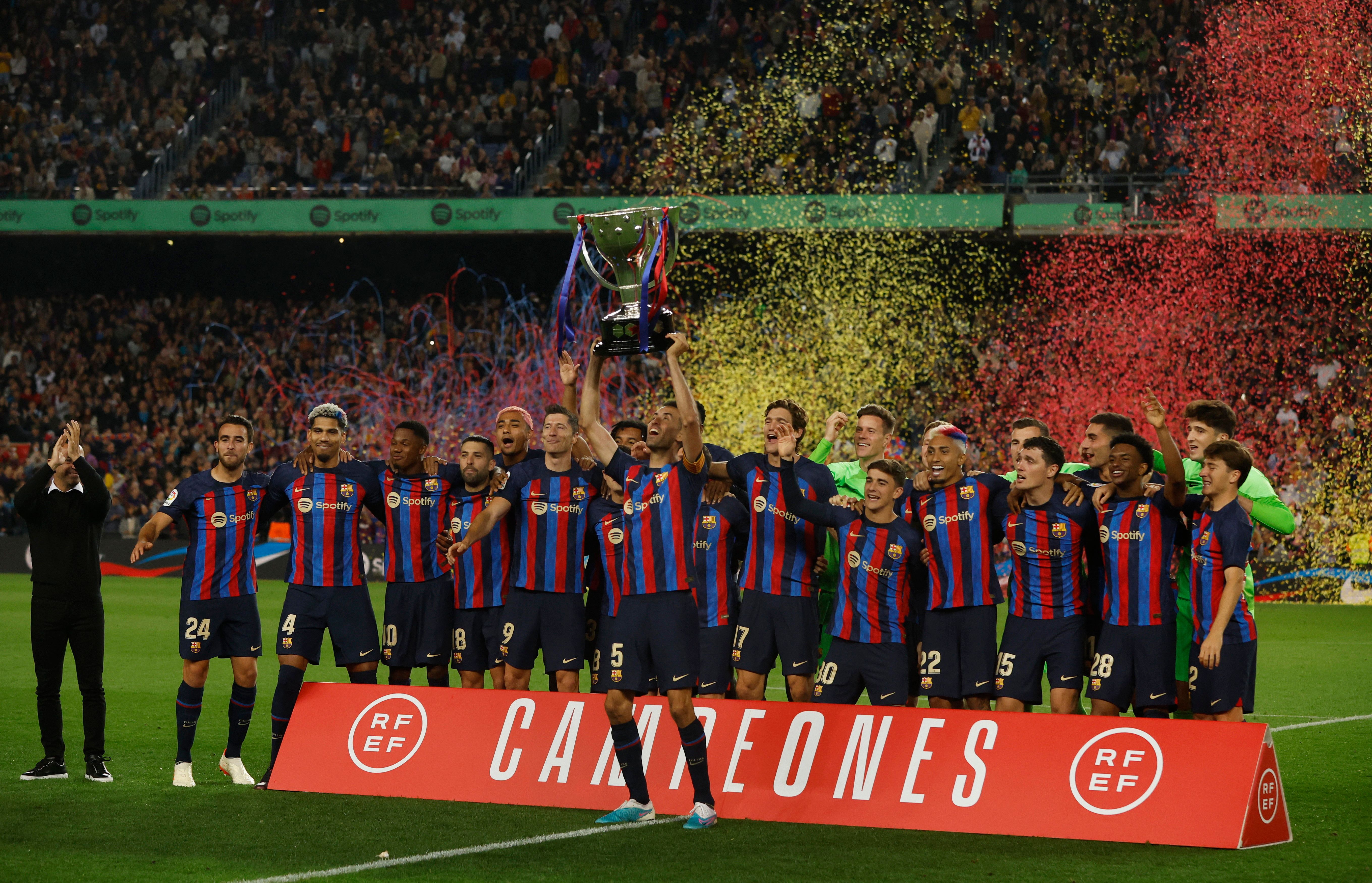 FC Barcelona's Sergio Busquets lifts the trophy alongside his teammates as they celebrate winning LaLiga after the match