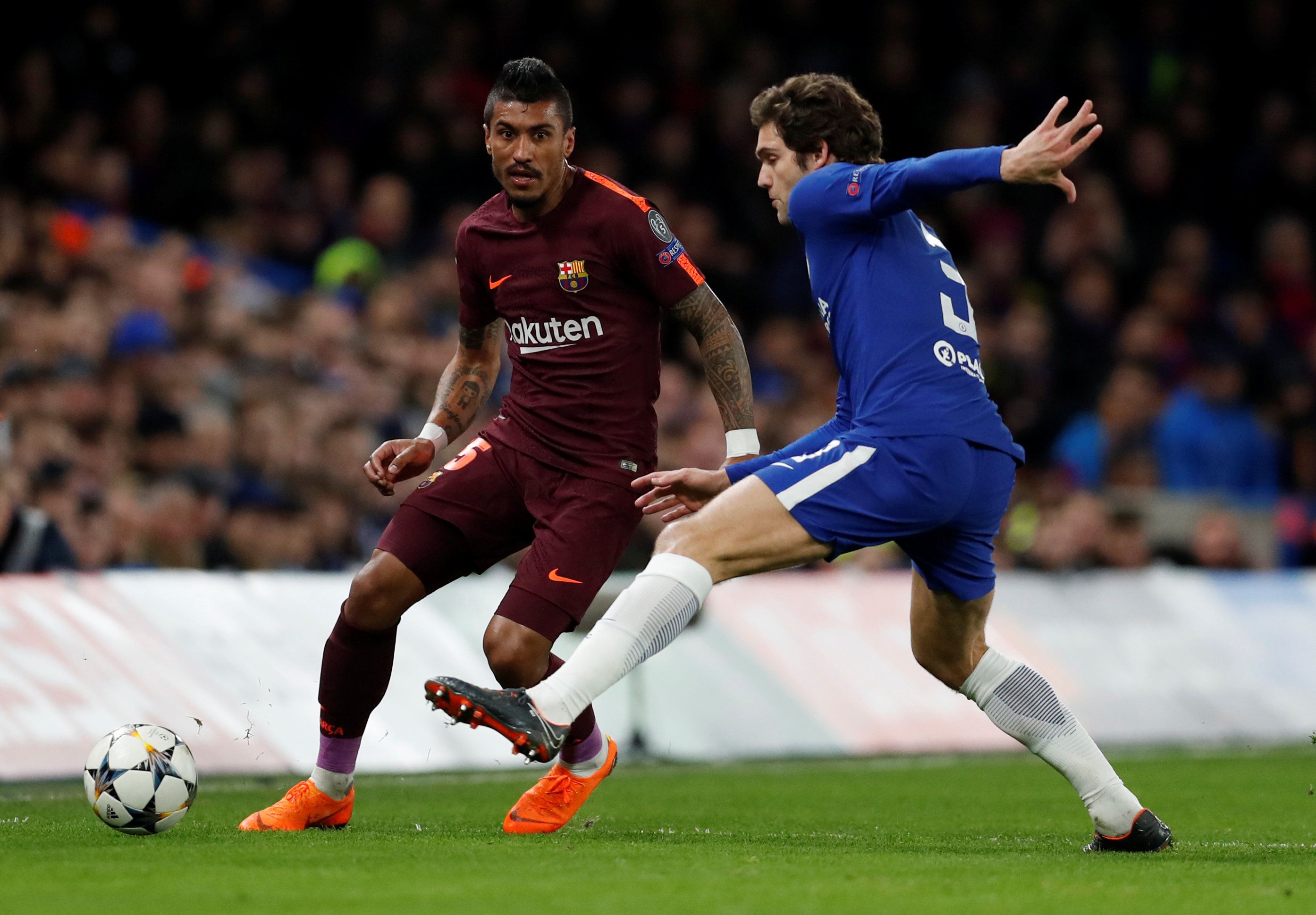 Barcelona's Paulinho in action with Chelsea's Marcos Alonso.