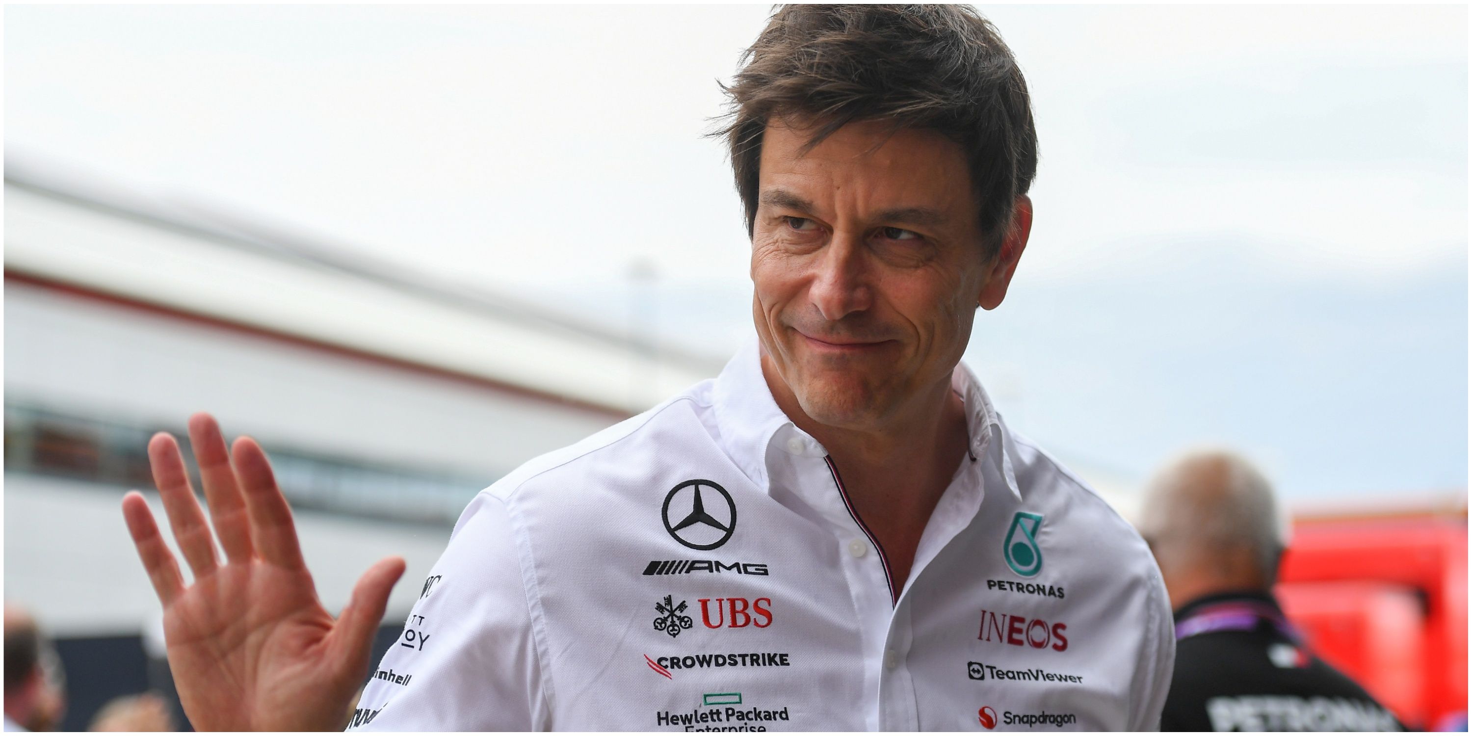 Toto Wolff waves in the British GP paddock