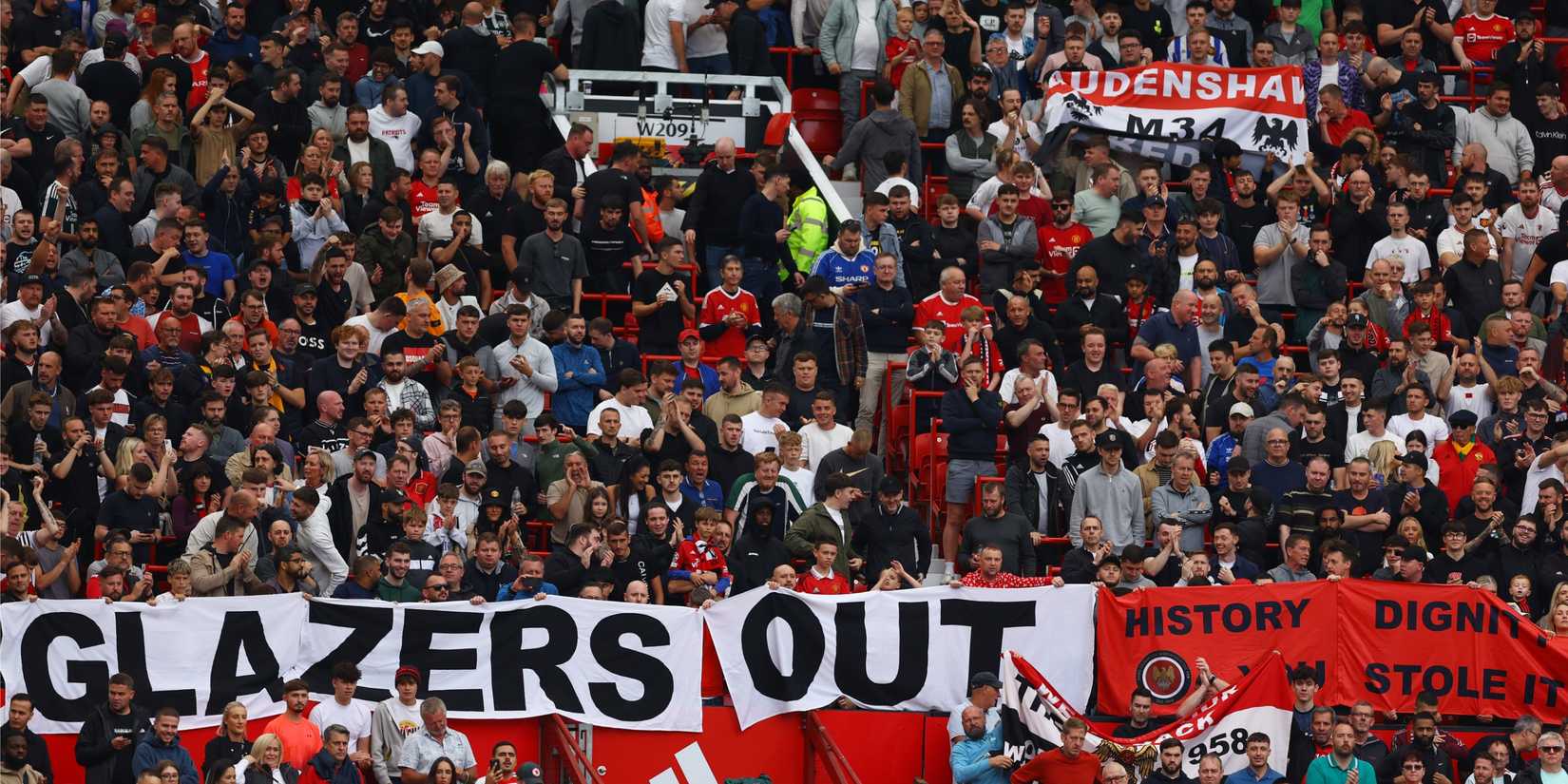 Manchester United fans inside Old Trafford display a Glazers Out banner