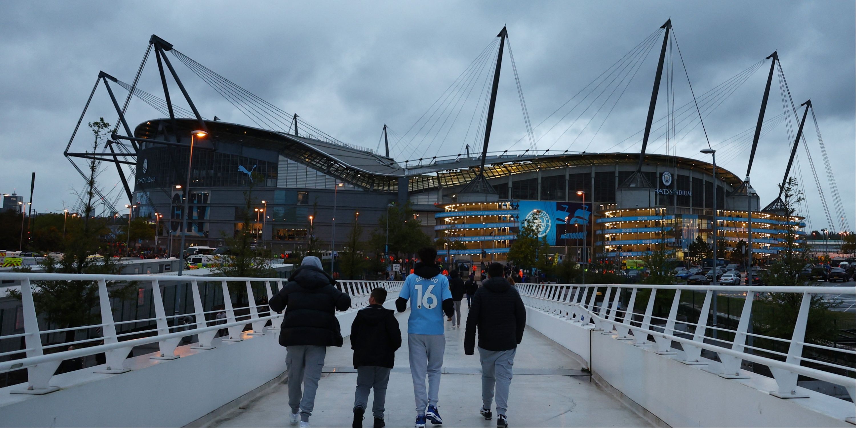 Manchester City fans walk to the Etihad Stadium.