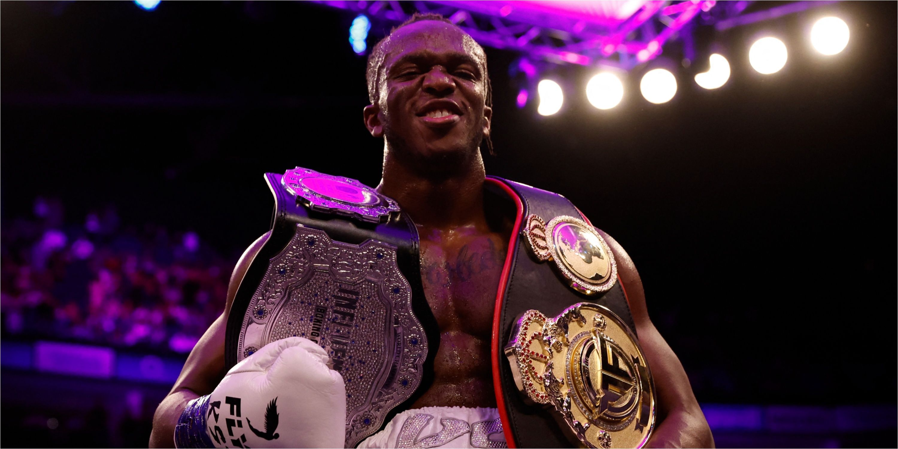 KSI celebrates with his belts after defeating Swarmz and Pineda