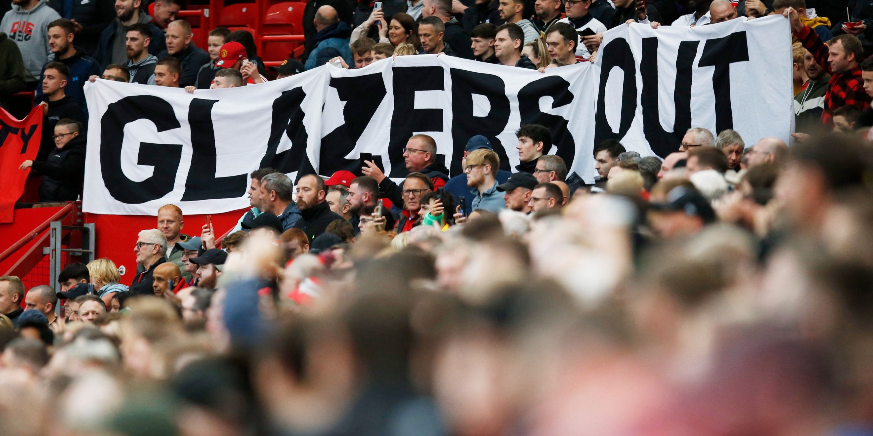 Manchester United fans display a Glazers Out banner inside Old Trafford