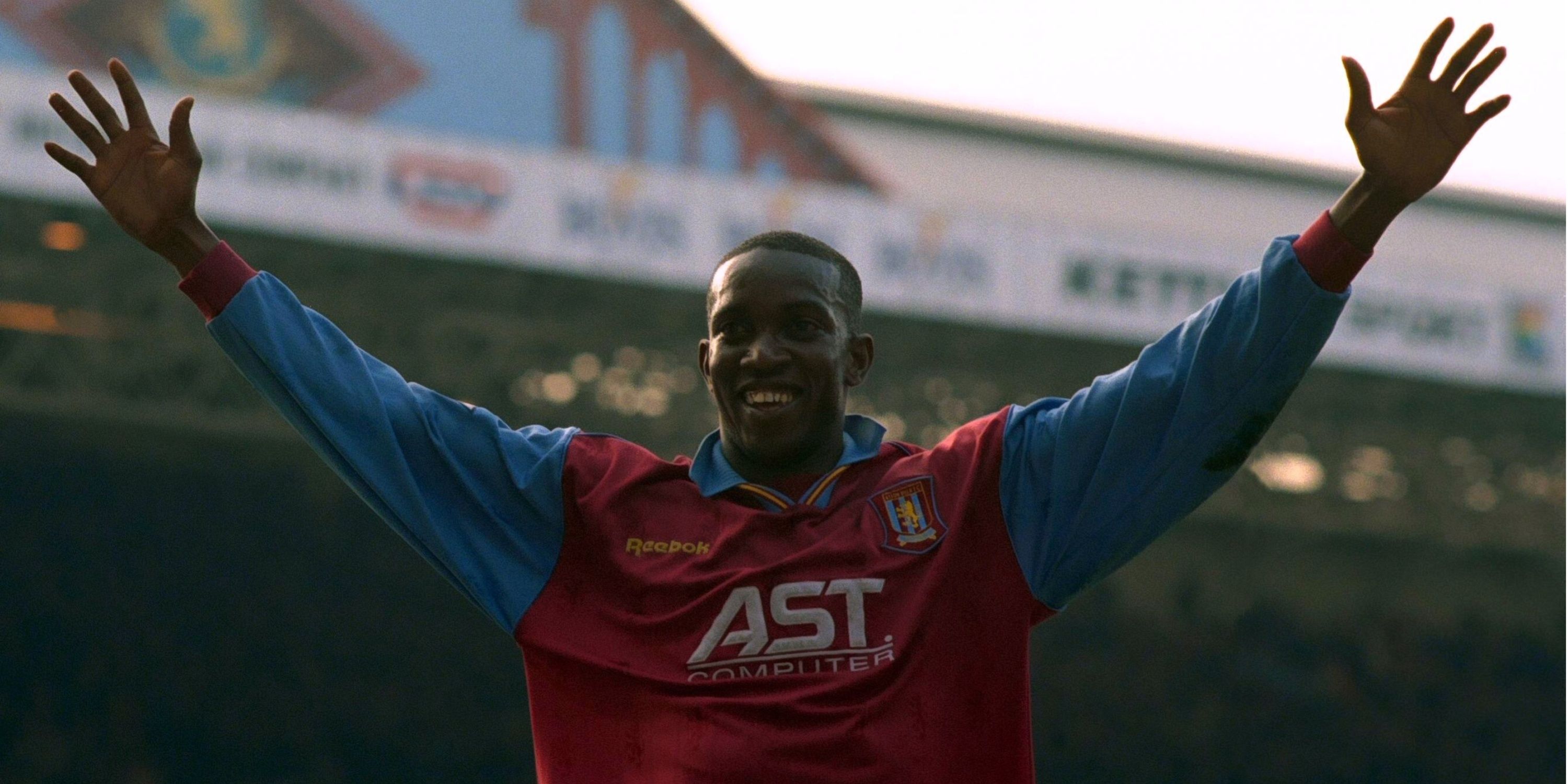 Aston Villa's Dwight Yorke celebrates scoring with his arms aloft. 