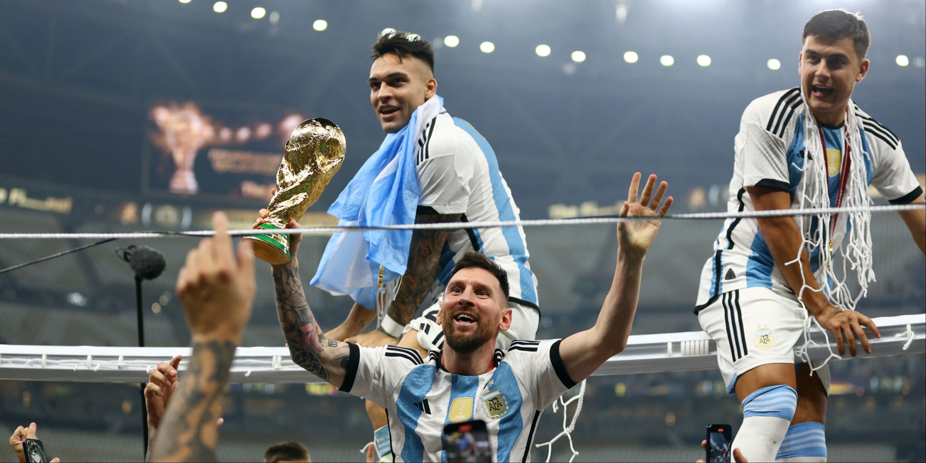 Argentina's Lionel Messi celebrates winning the World Cup with the trophy as Argentina's Lautaro Martinez and Paulo Dybala