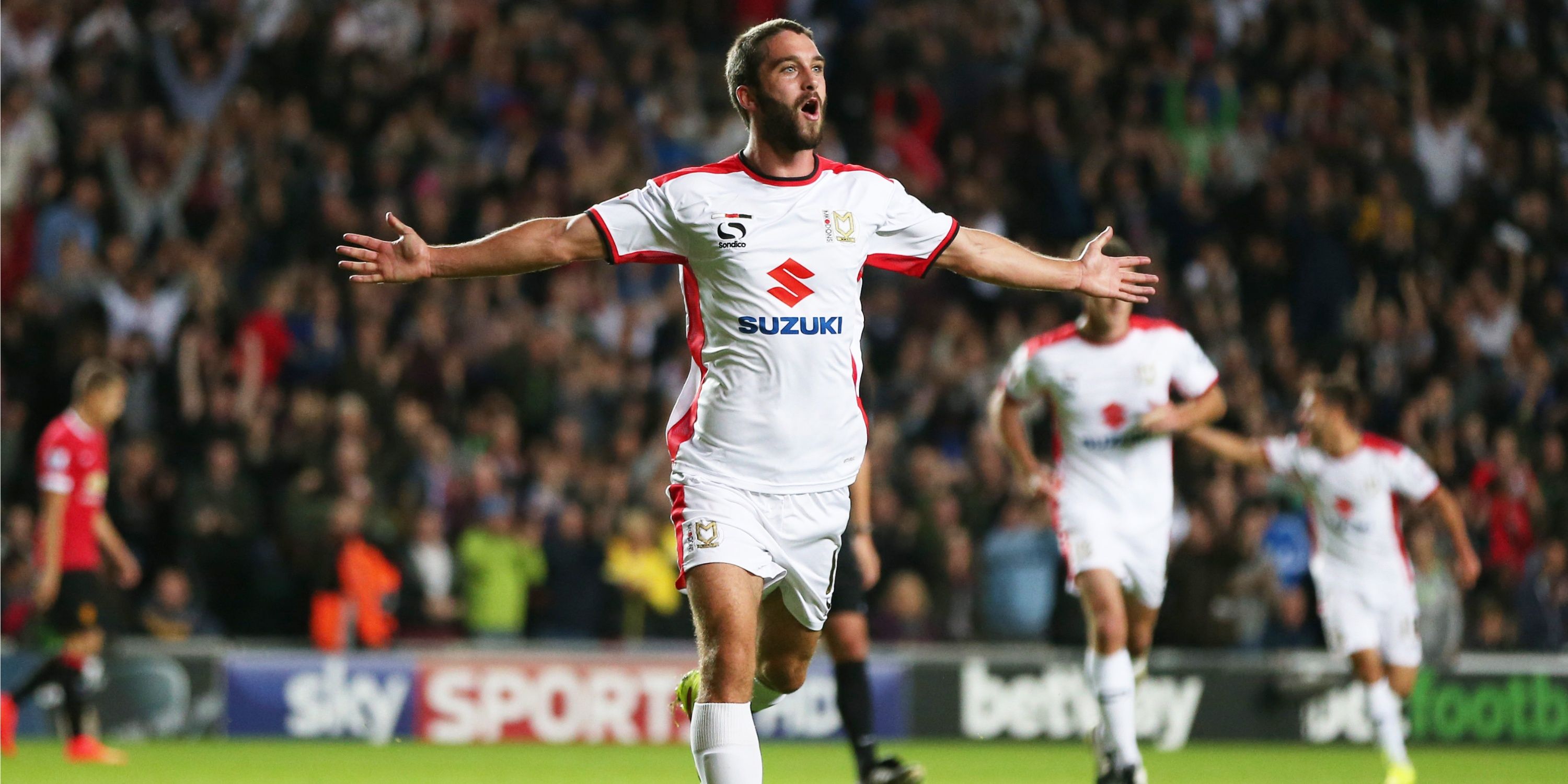 MK Dons striker Will Grigg celebrates scoring against Manchester United. 