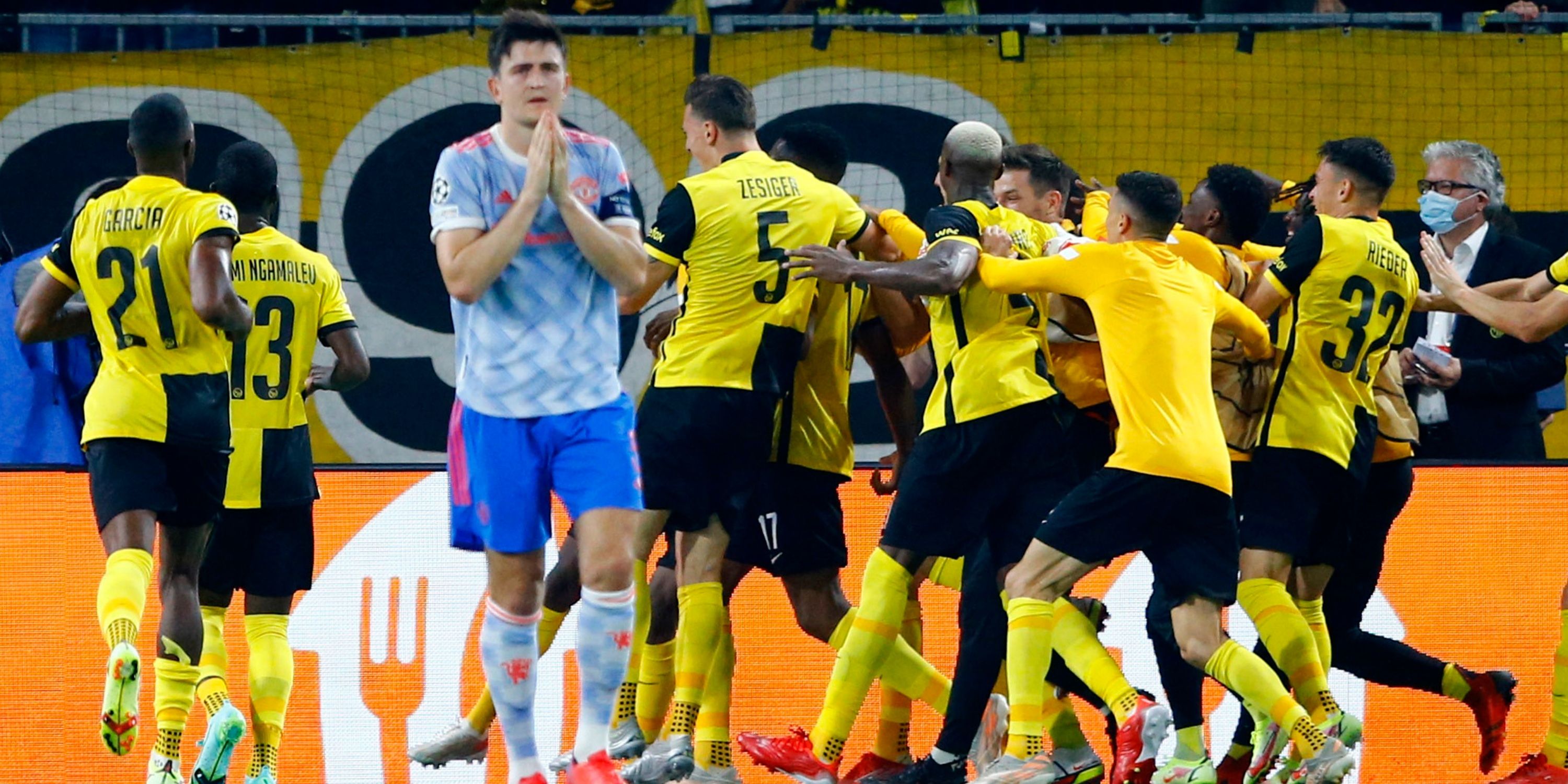 Manchester United's Harry Maguire looks crestfallen as the Young Boys players celebrate behind him.