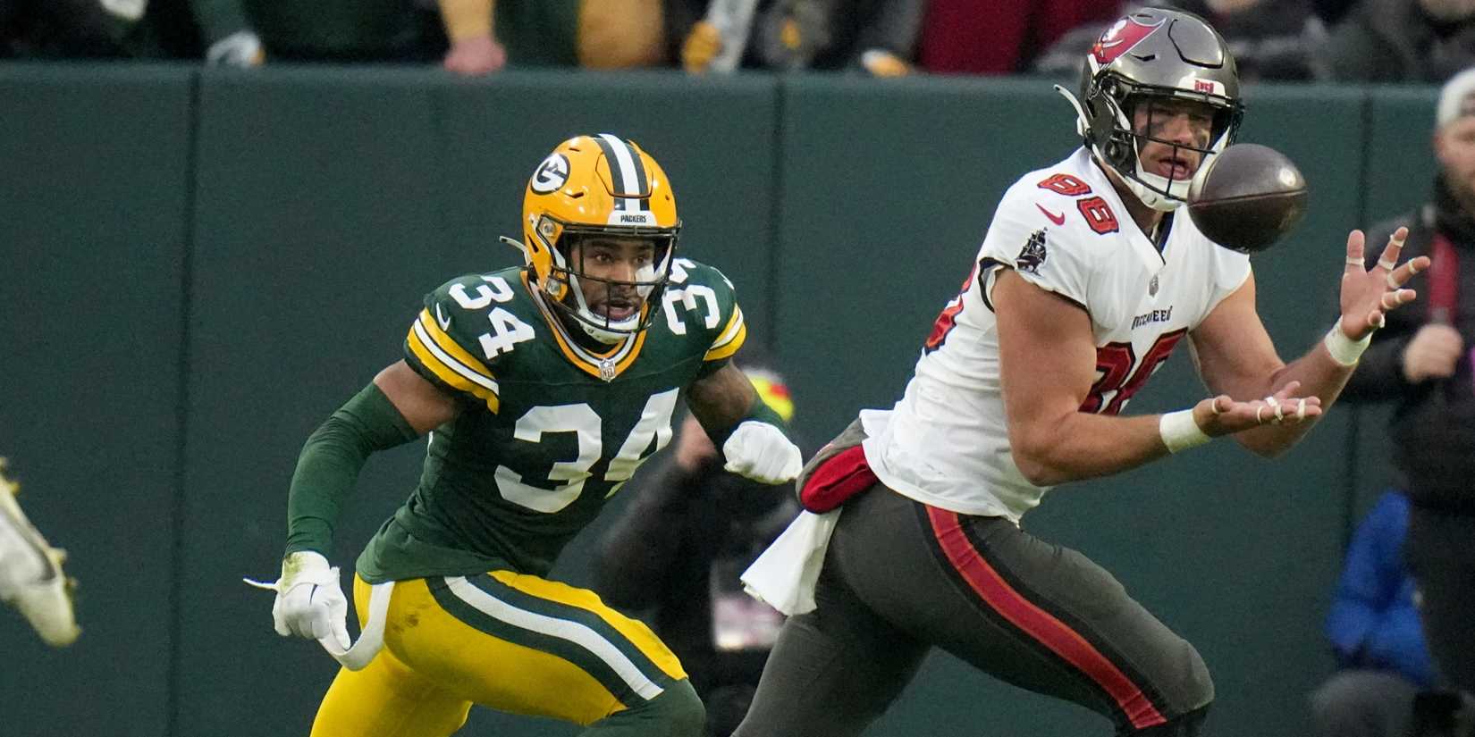 Cade Otton (88) catches a two-yard touchdown reception while being covered by Green Bay Packers safety Jonathan Owens (34) during the third quarter of their game at Lambeau Field. Mandatory Credit- Mark Hoffman-USA TODAY Sports