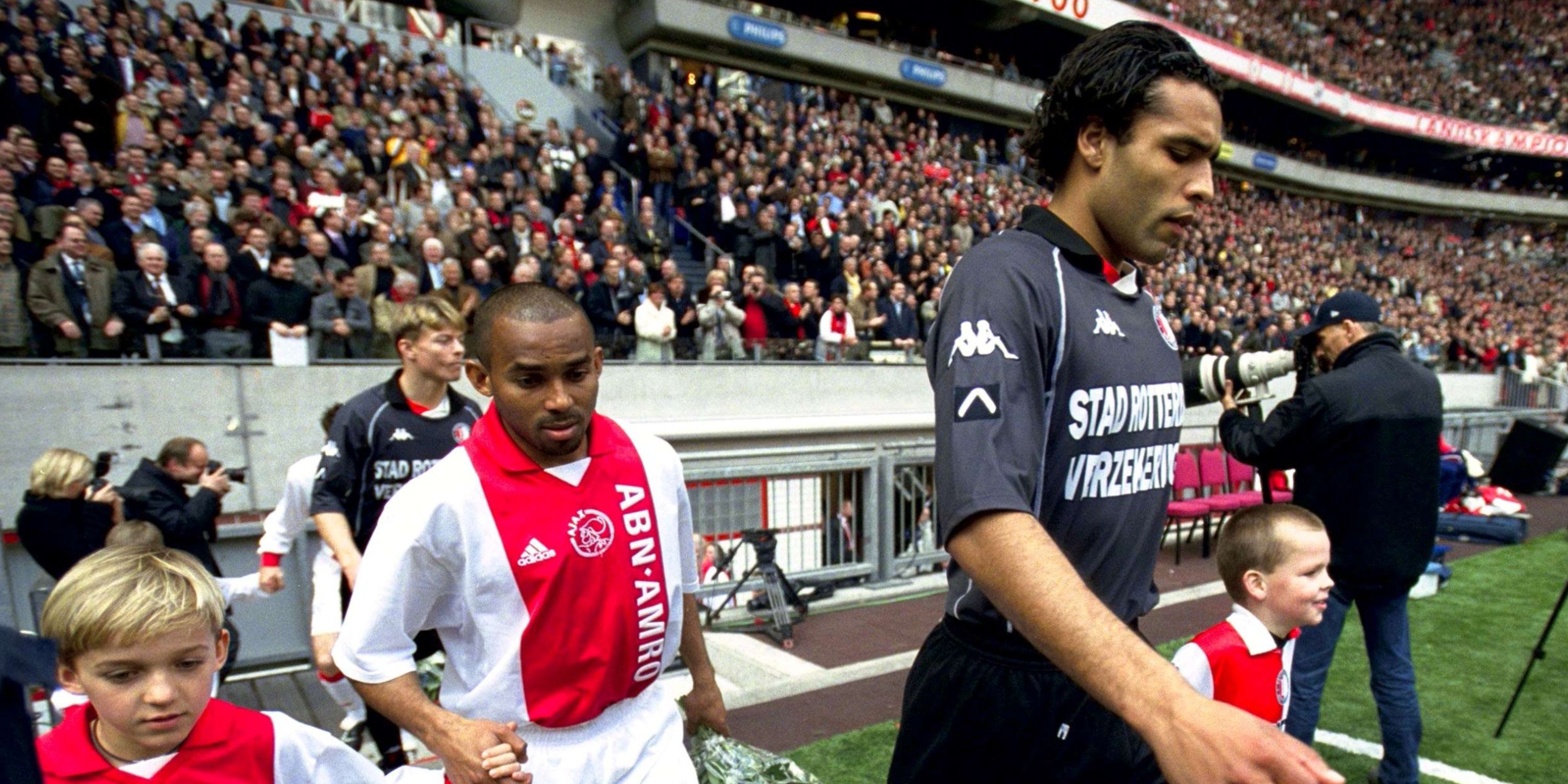 Feyenoord's Pierre van Hooijdonk and Ajax's Wamberto make their way to the pitch