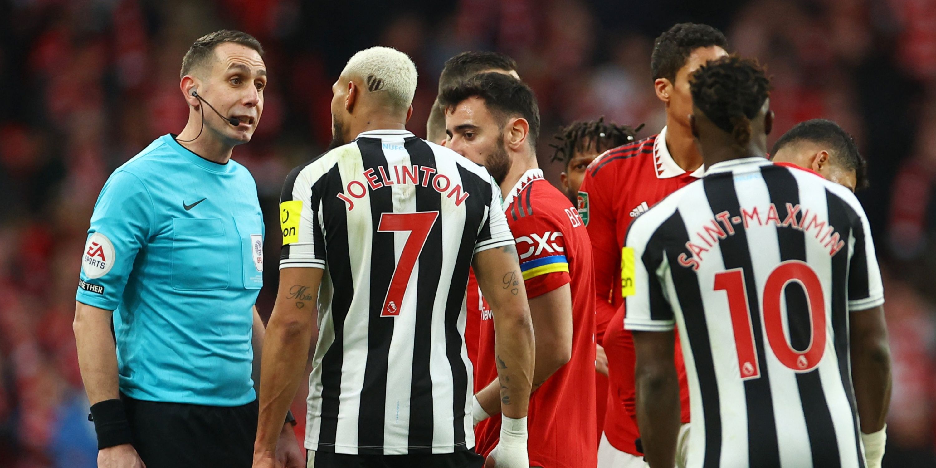 Referee David Coote speaks with Newcastle's Joelinton.