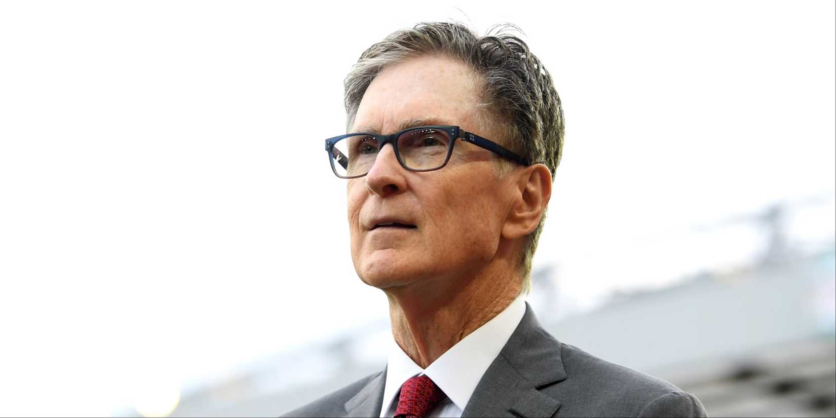 Liverpool owner John W. Henry walking along the touchline at Anfield