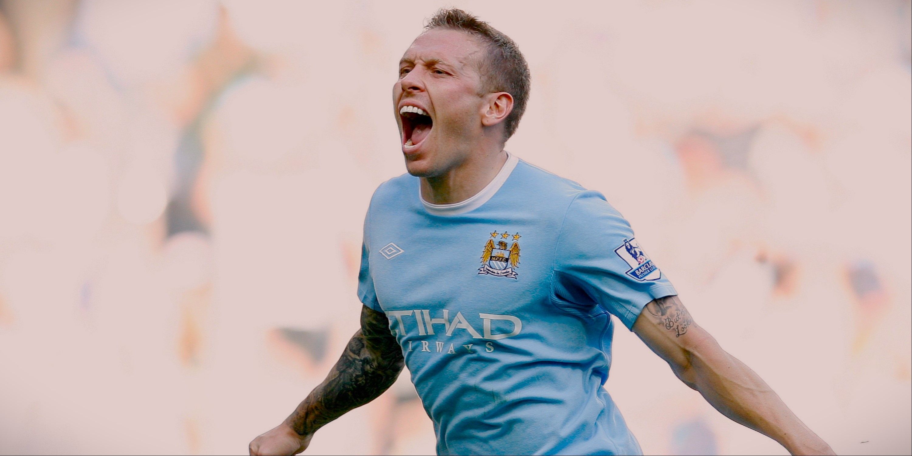Craig Bellamy celebrates scoring for Manchester City with his arms outstretched. 