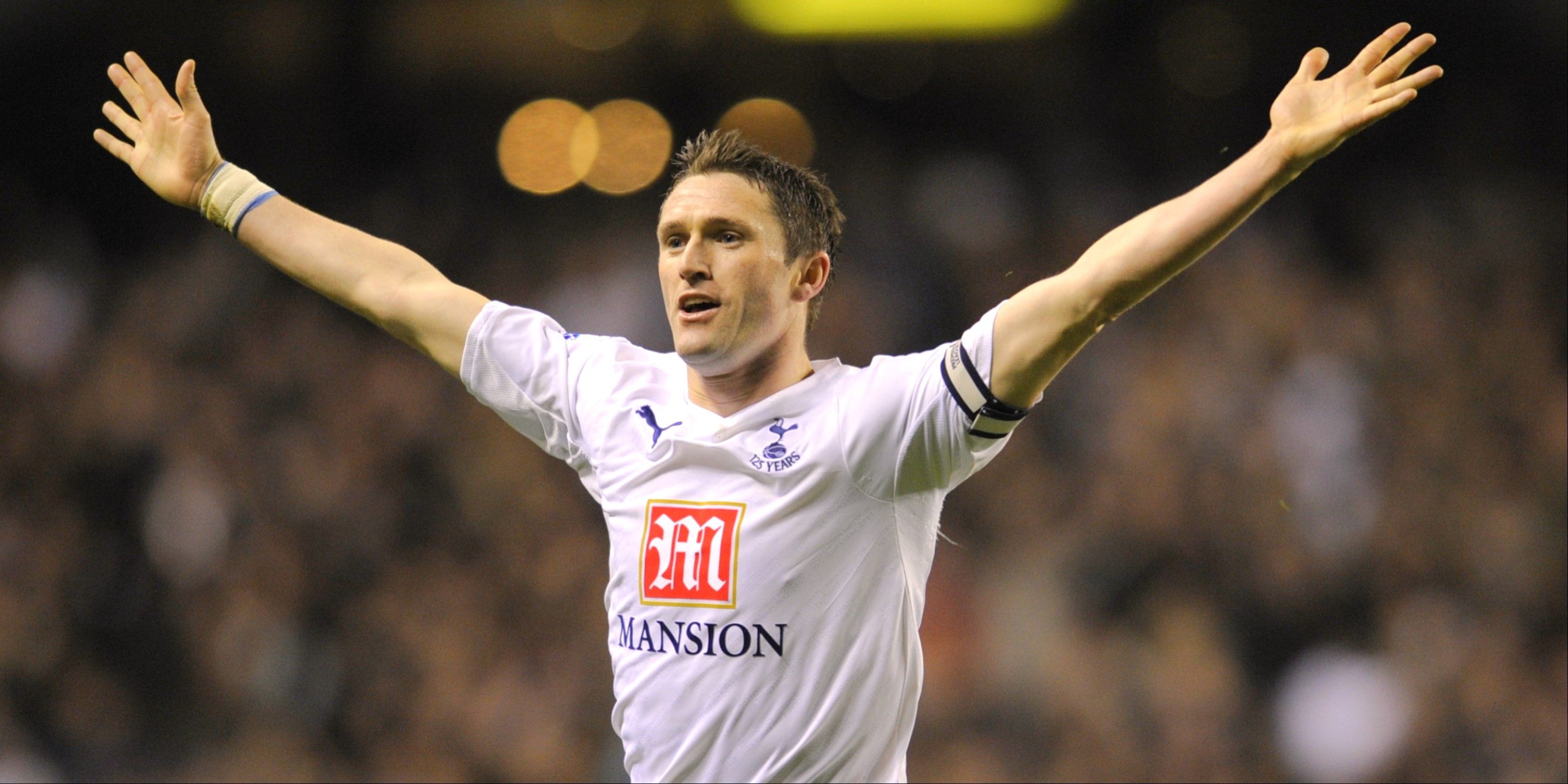 Robbie Keane celebrates scoring for Tottenham with his arms outstretched. 