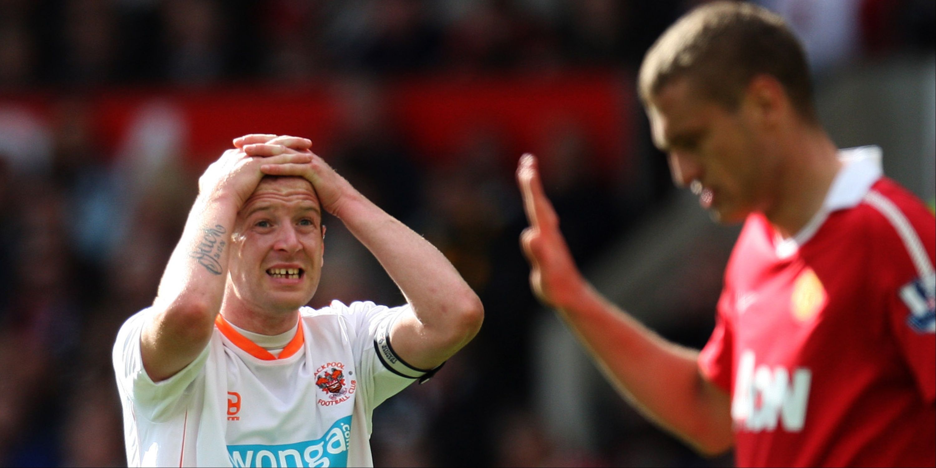 Blackpool's Charlie Adam looks dejected alongside Manchester United's Nemanja Vidic.