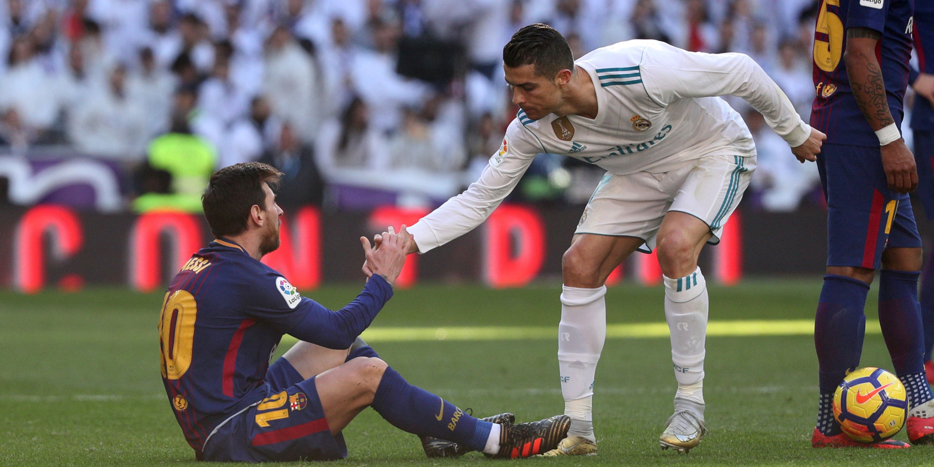 Cristiano Ronaldo helping Lionel Messi off the ground during a match between Barcelona and Real Madrid